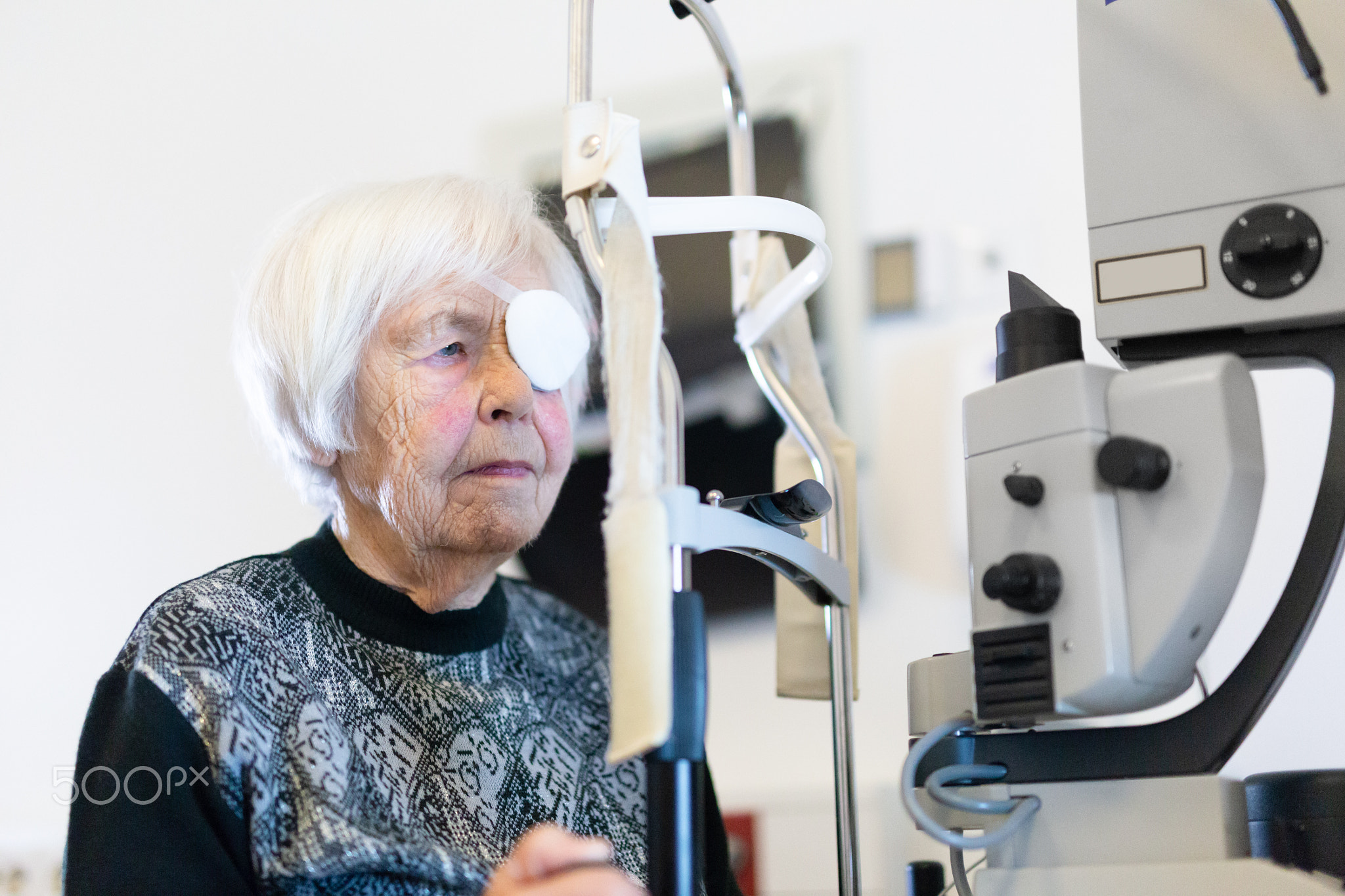 Senior woman wearing eye pathc after laser surgery procedure at ophthalmology clinic.