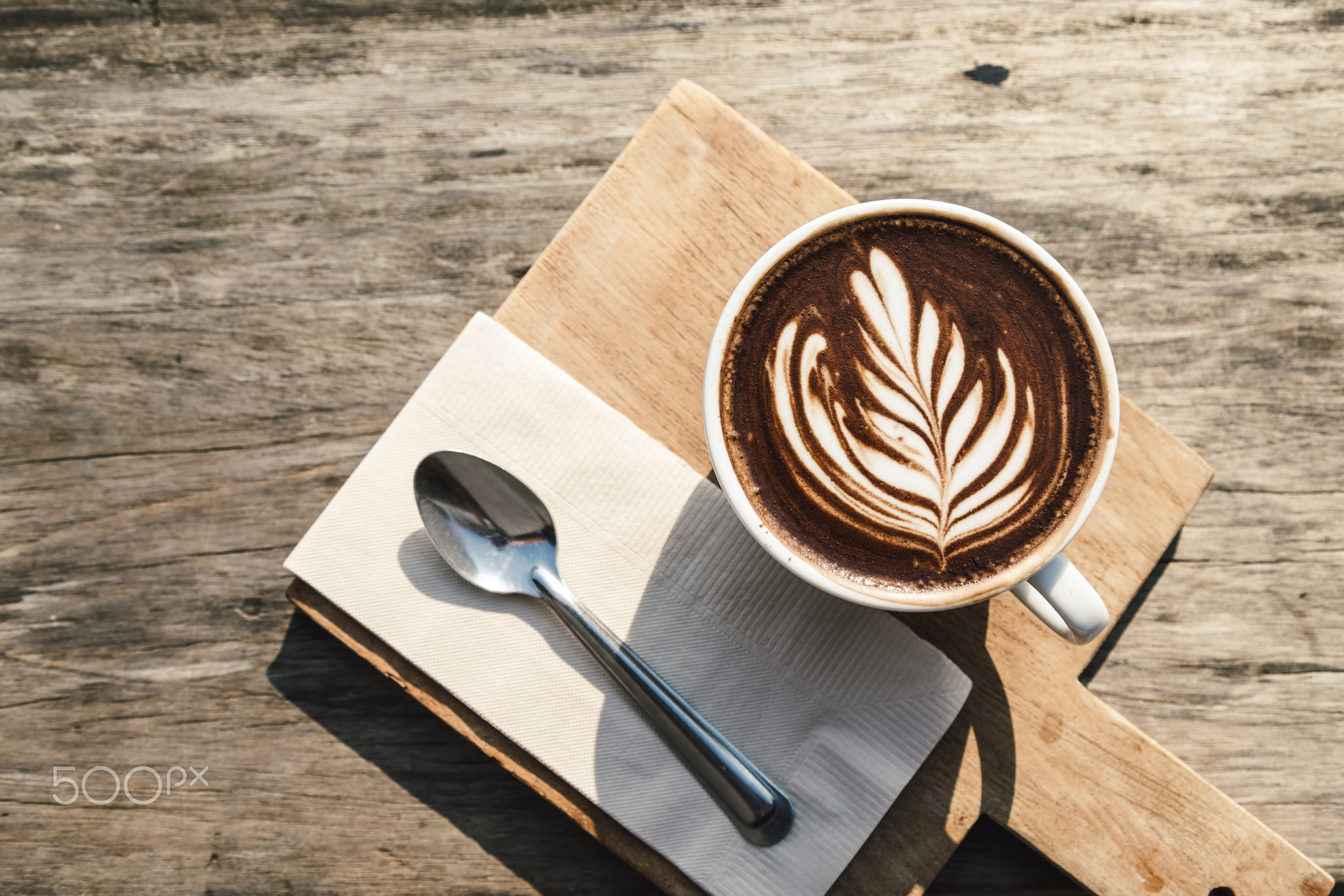 Top view of hot coffee cup cappuccino art, spoon, tissue, choppi