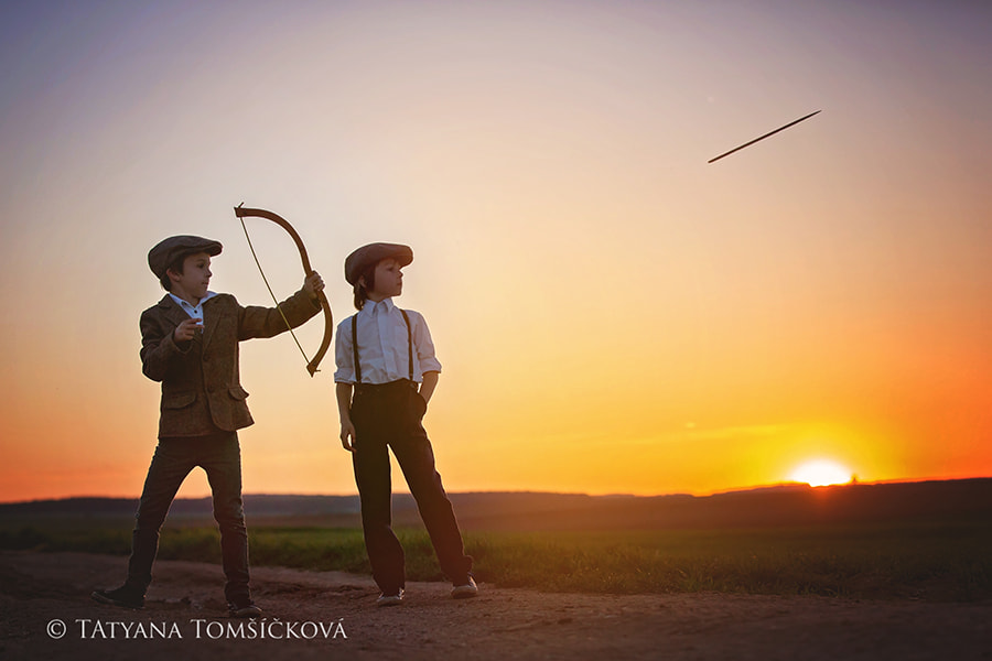 Silhouette of children playing with bow and arrows, archery shoots