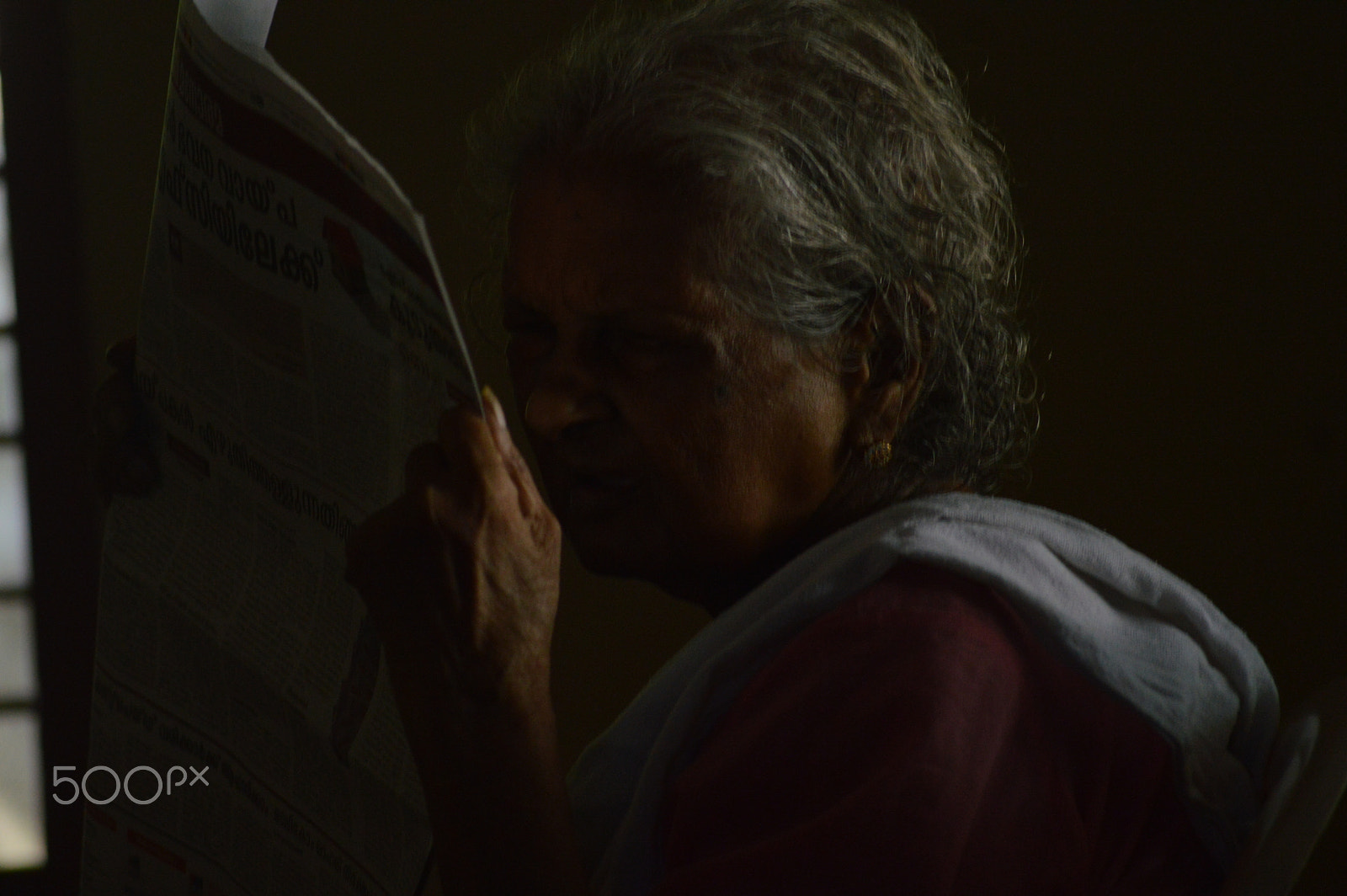 Nikon D3200 sample photo. Old woman trying to read newspaper photography
