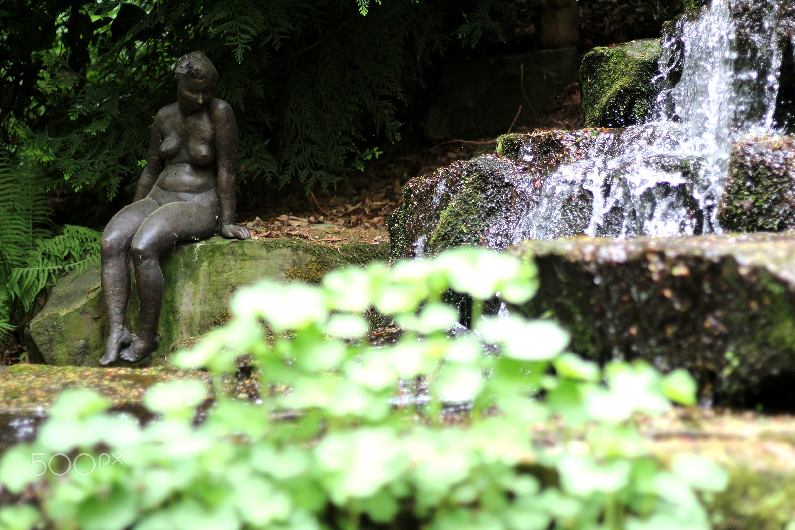 Canon EOS 100D (EOS Rebel SL1 / EOS Kiss X7) + Canon EF 50mm F1.8 STM sample photo. Statue next to small waterfall photography