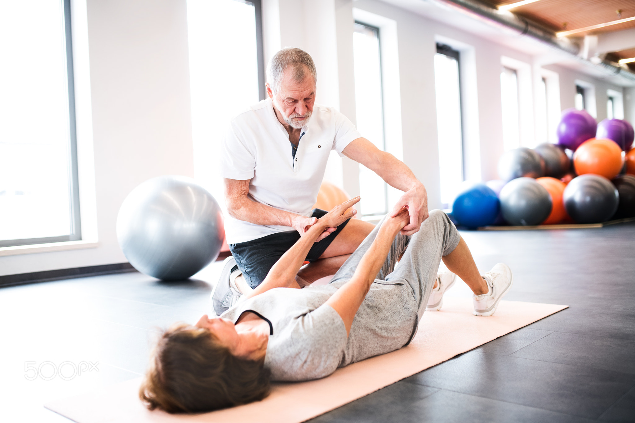 Senior physiotherapist working with a female patient.