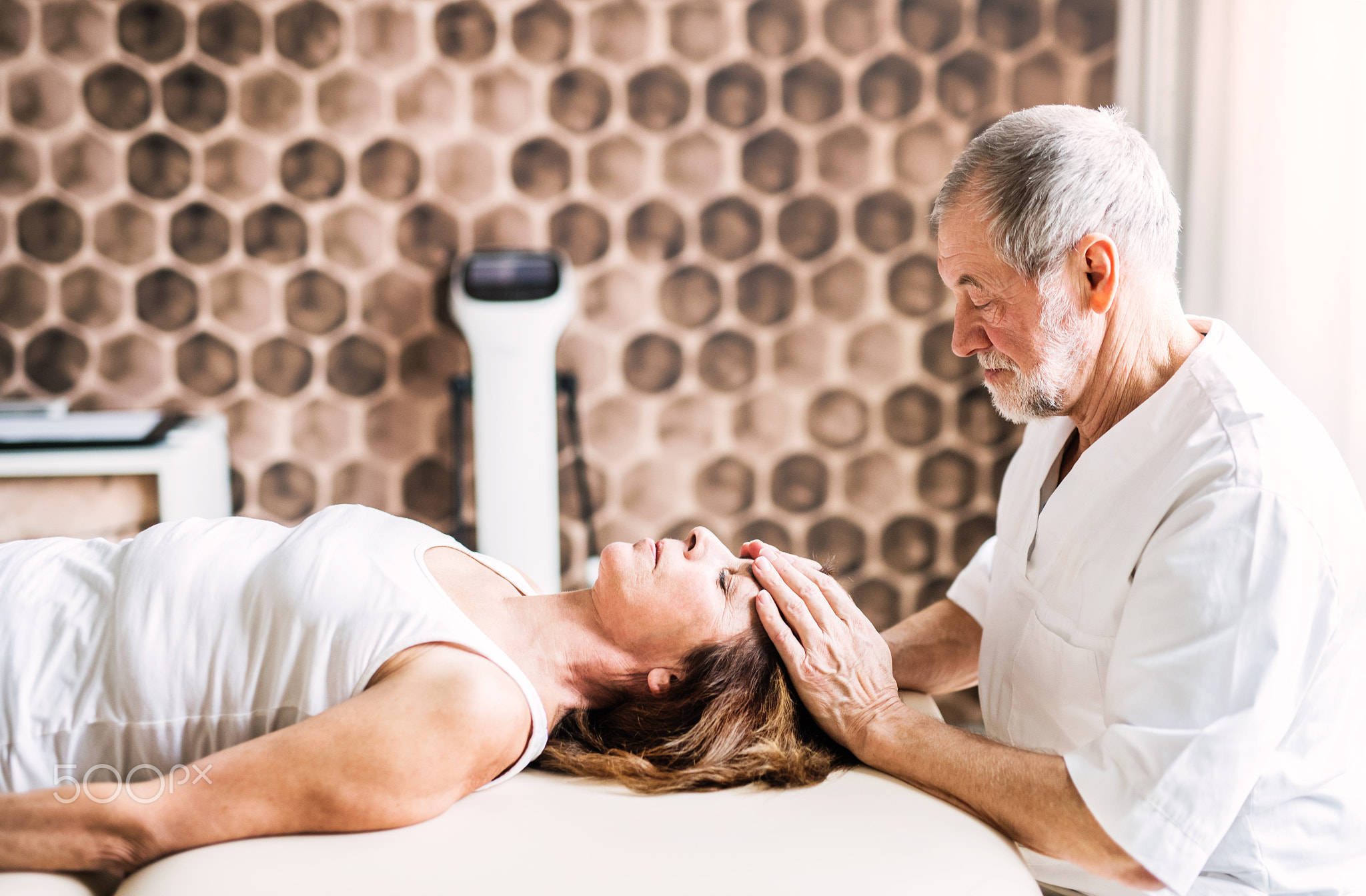 Senior physiotherapist working with a female patient.