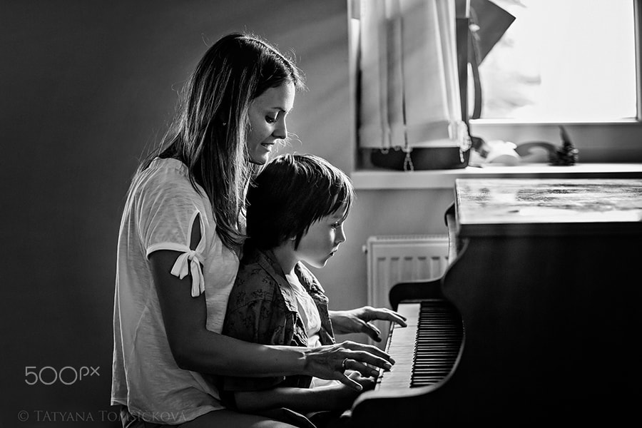 Mother and preschool child, cute boy, playing piano at home