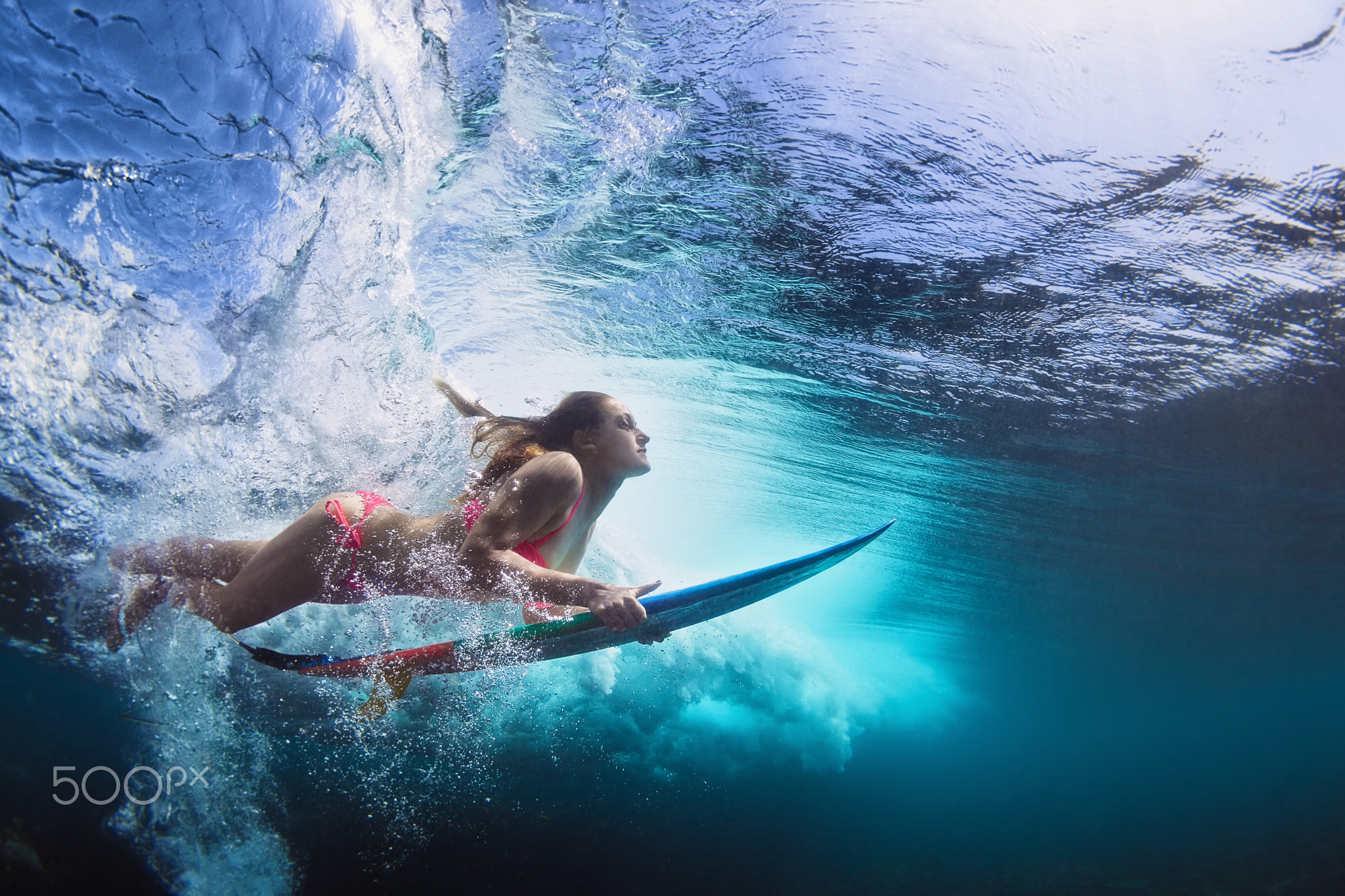 Young girl in bikini surf board dive underwater