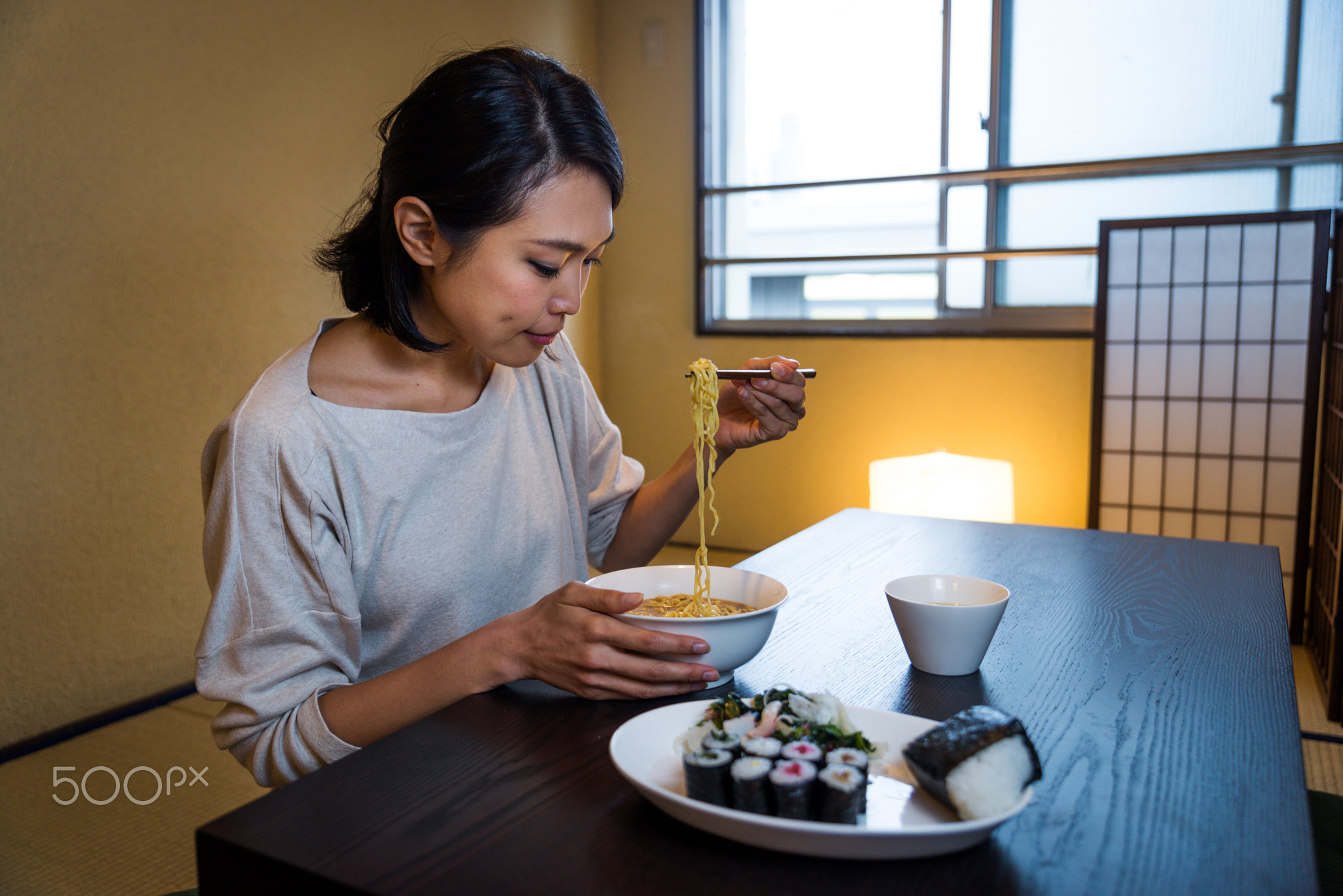 Japanese woman eating in a traditional apartment