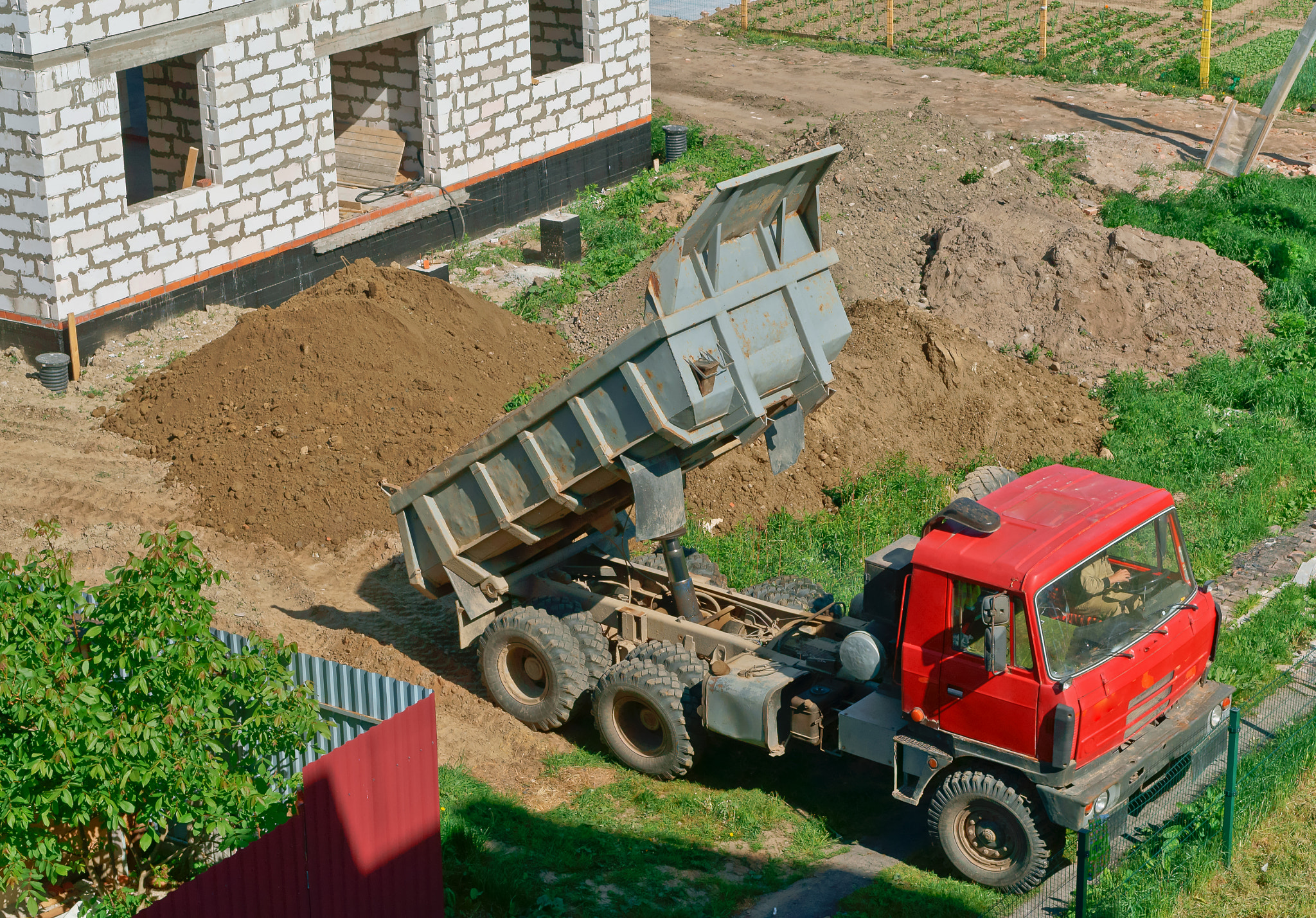 Sony Alpha NEX-3N sample photo. The dump truck near the house under construction, the truck and building of the house from a... photography