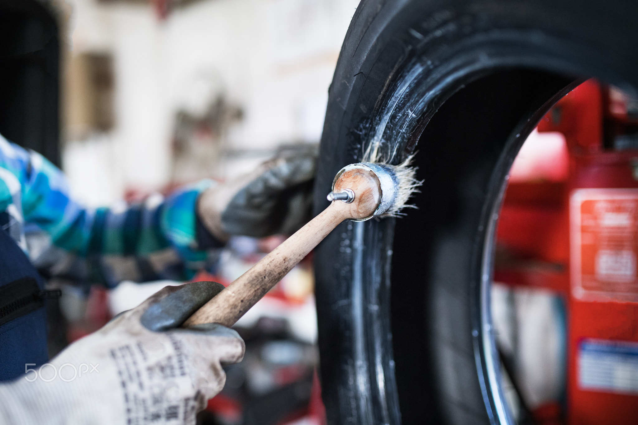 Senior female mechanic repairing a car in a garage.