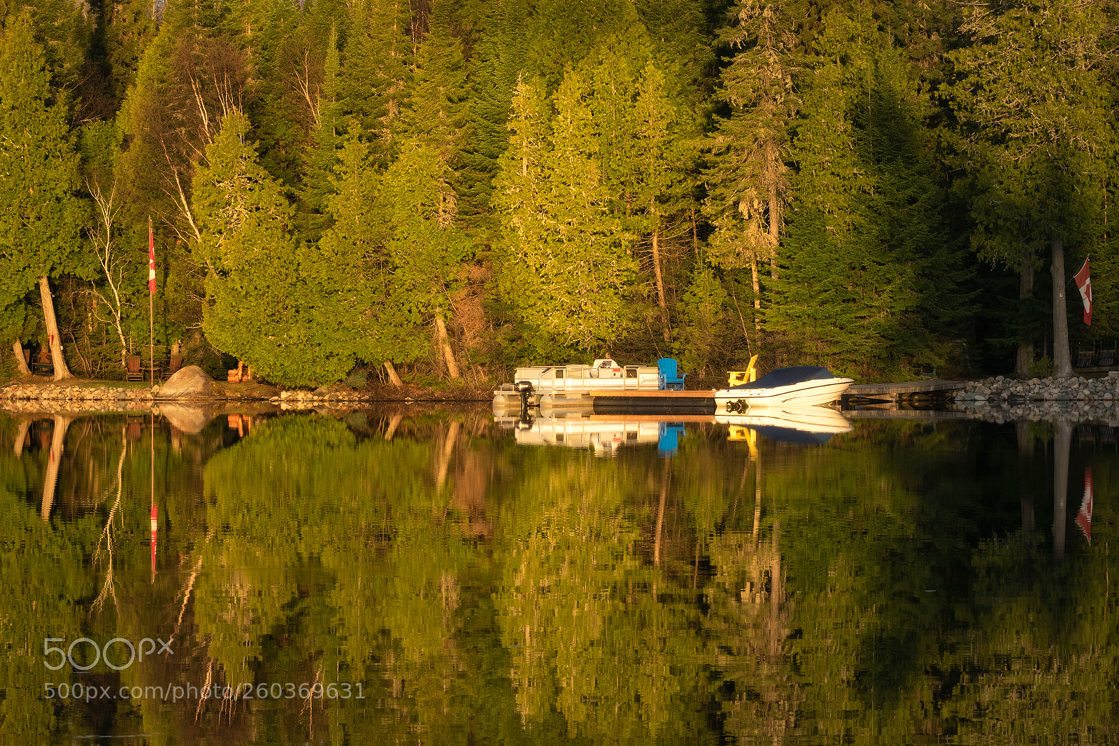 Sony Cyber-shot DSC-RX10 III sample photo. 'flags, boats, trees, rocks photography