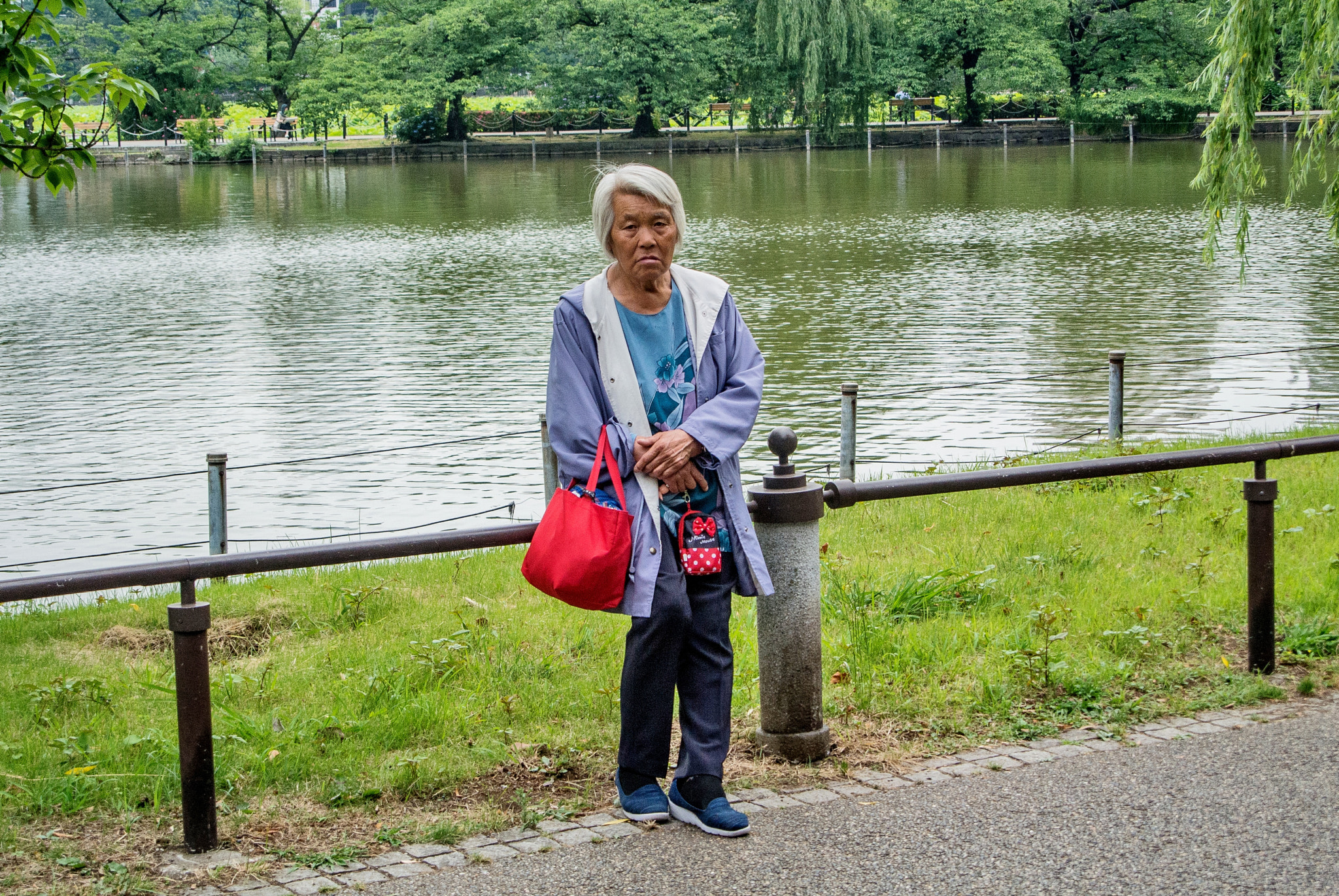 Nikon 1 V1 sample photo. A woman nestling at the side of a pond photography