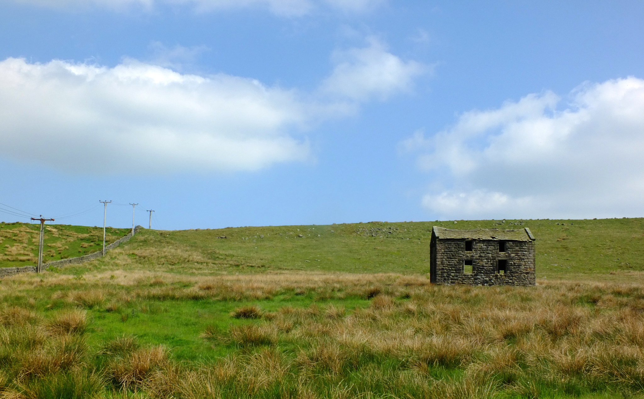 Fujifilm X-S1 sample photo. An old abandoned stone farmhouse in green pasture on high pennine moorland with bright blue sky photography