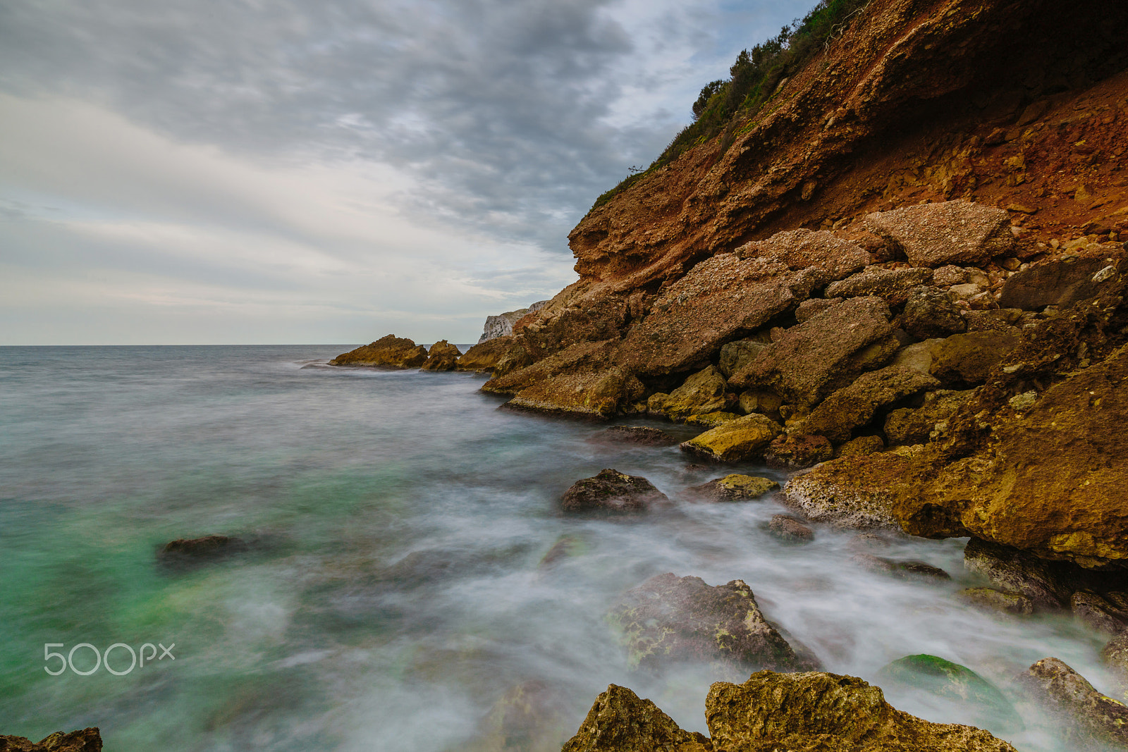 Sony a99 II sample photo. Sunset on the beach among the rocks near the city of denia. district of valencia, spain. photography