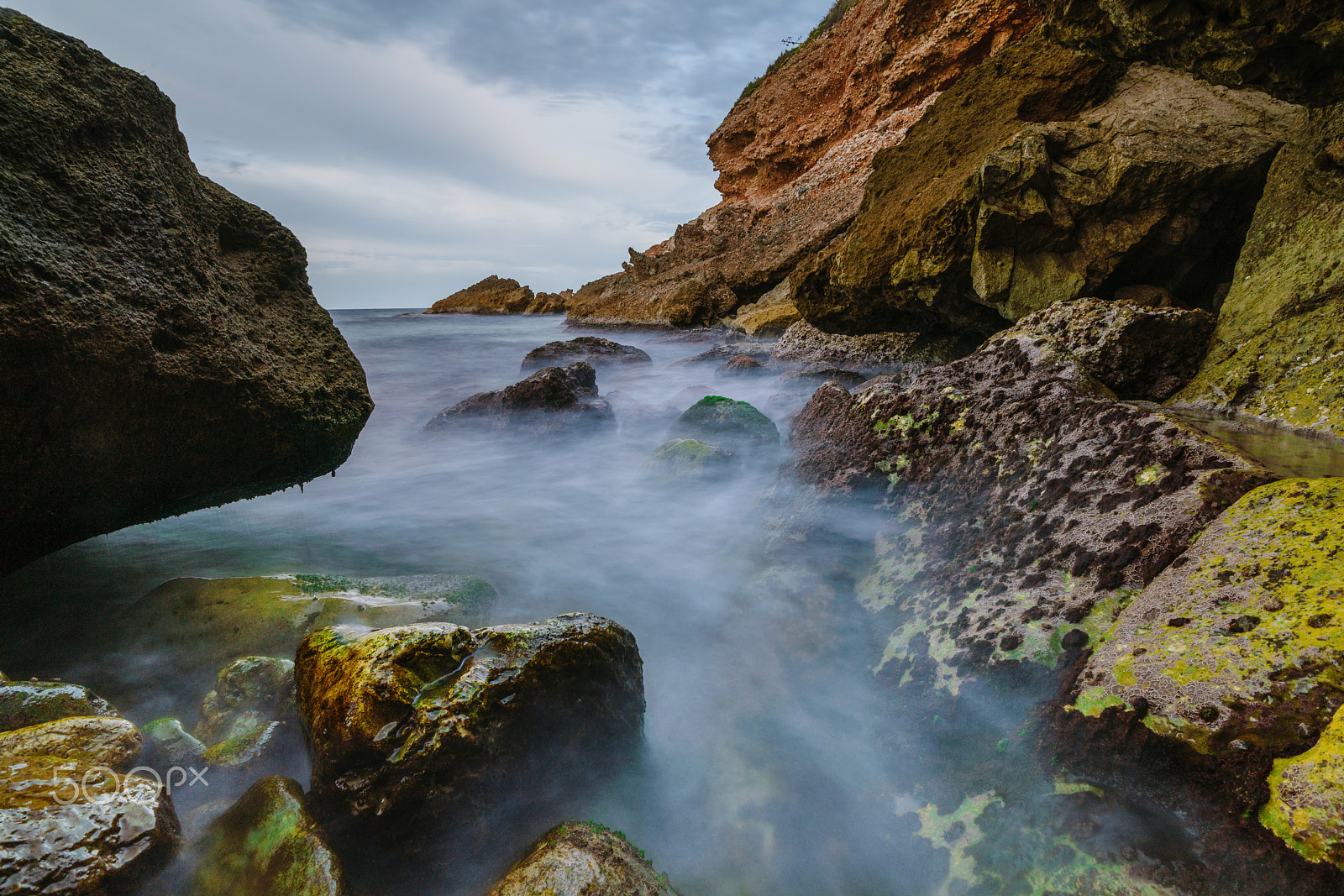 Sony a99 II sample photo. Sunset on the beach among the rocks near the city of denia. district of valencia, spain. photography