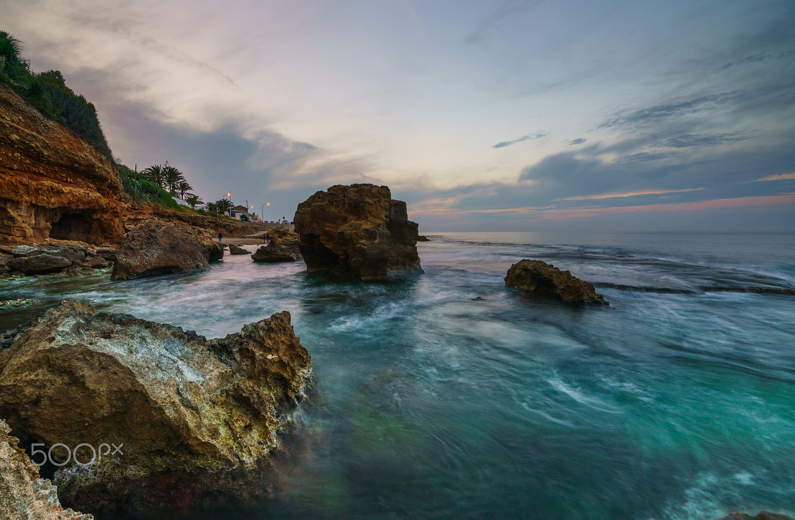Sony a99 II sample photo. Sunset on the beach among the rocks near the city of denia. district of valencia, spain. photography