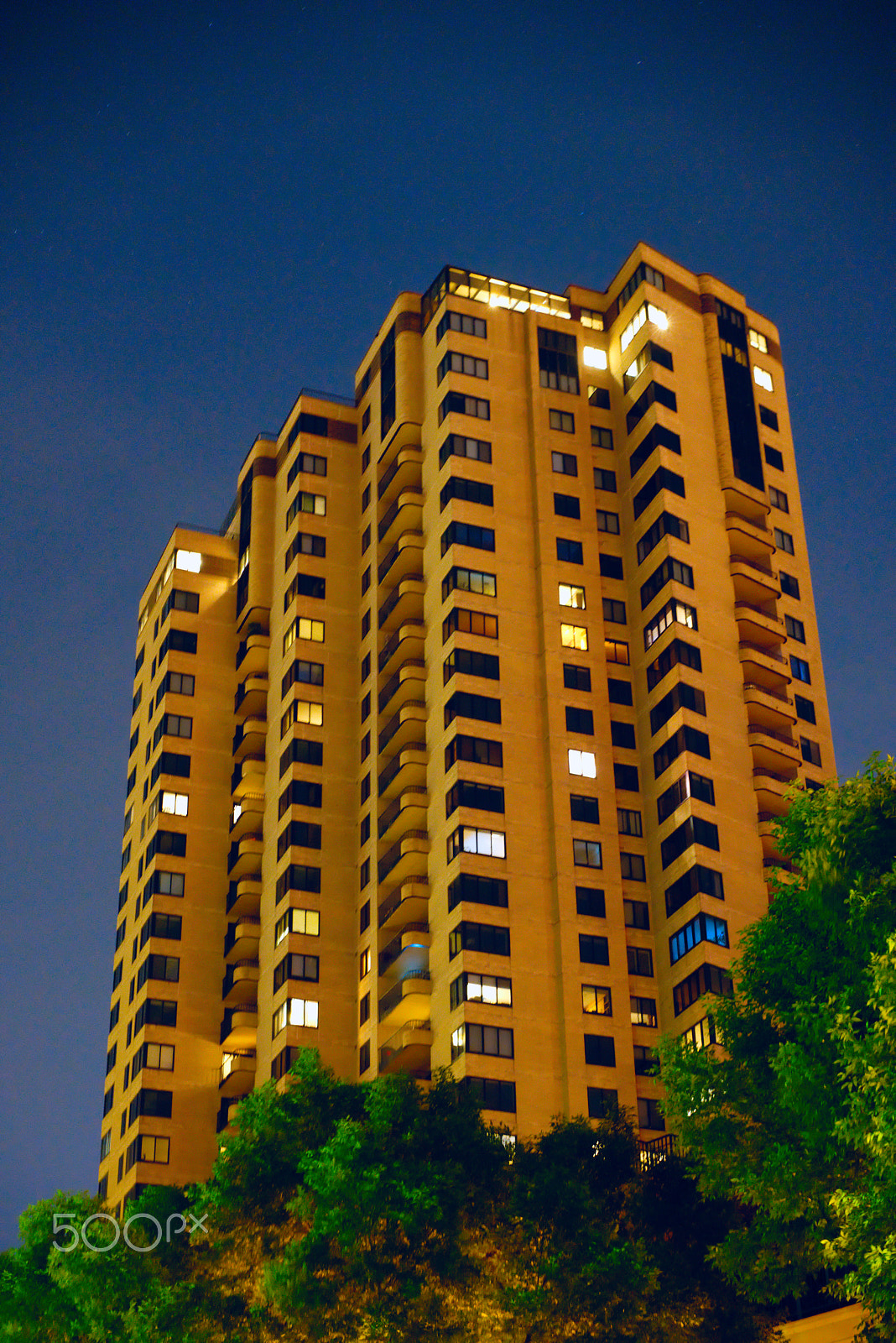 Sony a7R III + Sony Sonnar T* FE 55mm F1.8 ZA sample photo. Skyscraper set against blue sky and green trees photography