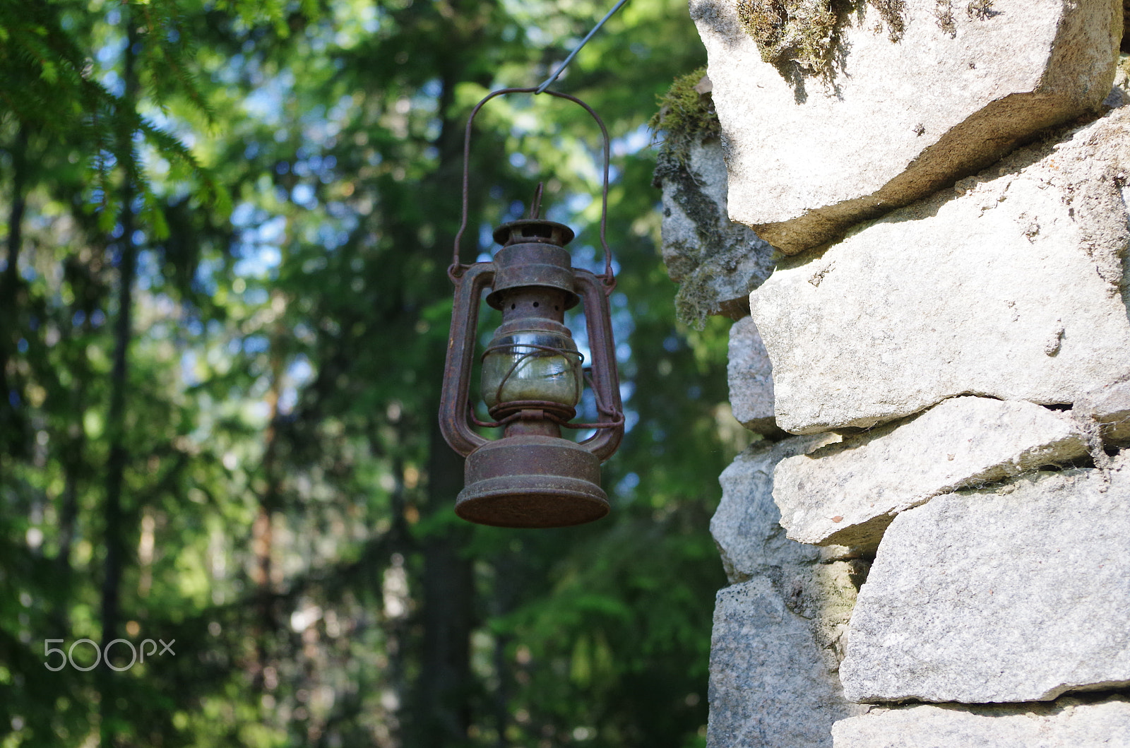 Pentax K-500 sample photo. An old lantern on an old stone house in a forest photography