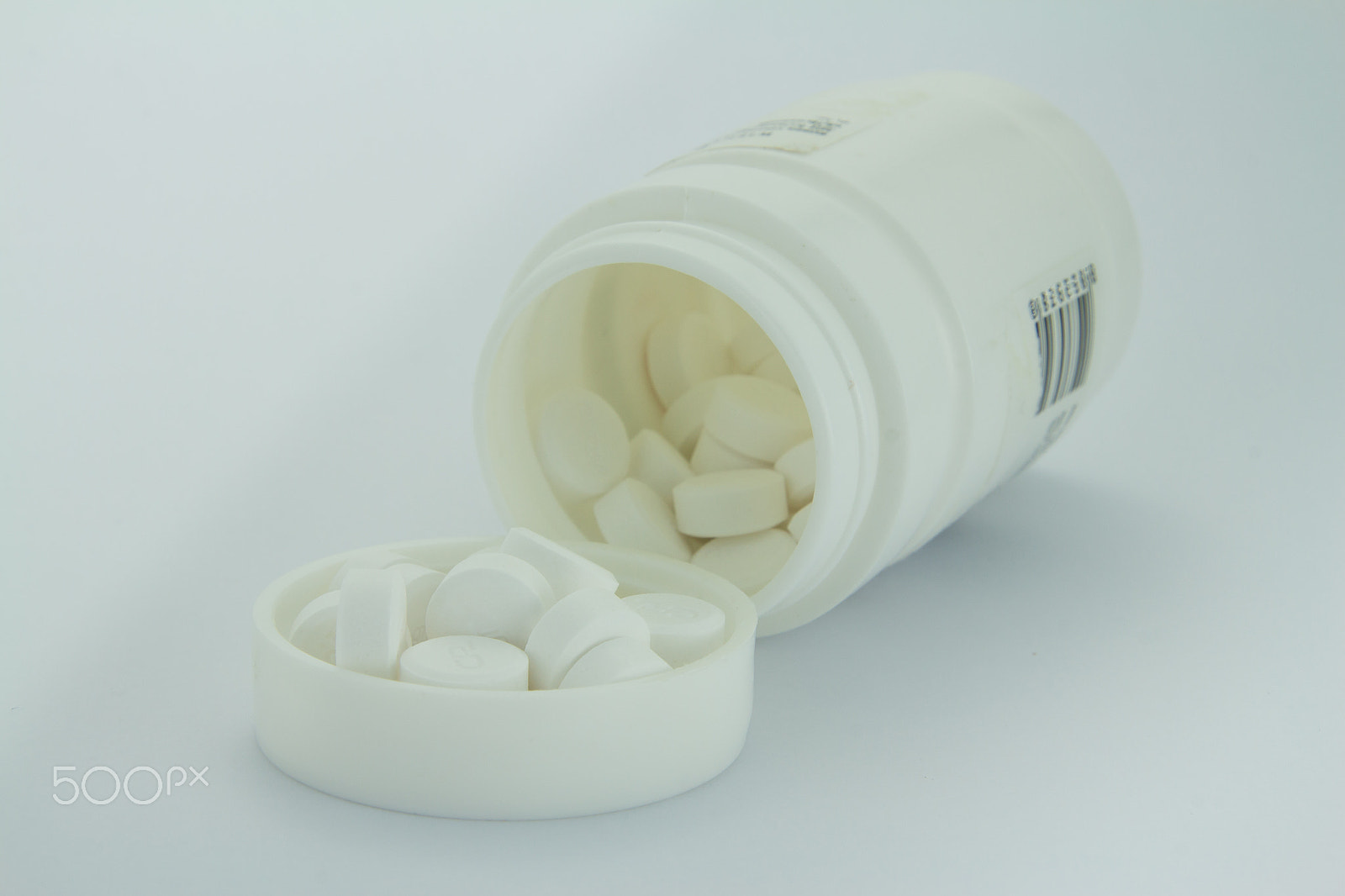 Canon EOS M sample photo. White pills an pill bottle on white background photography