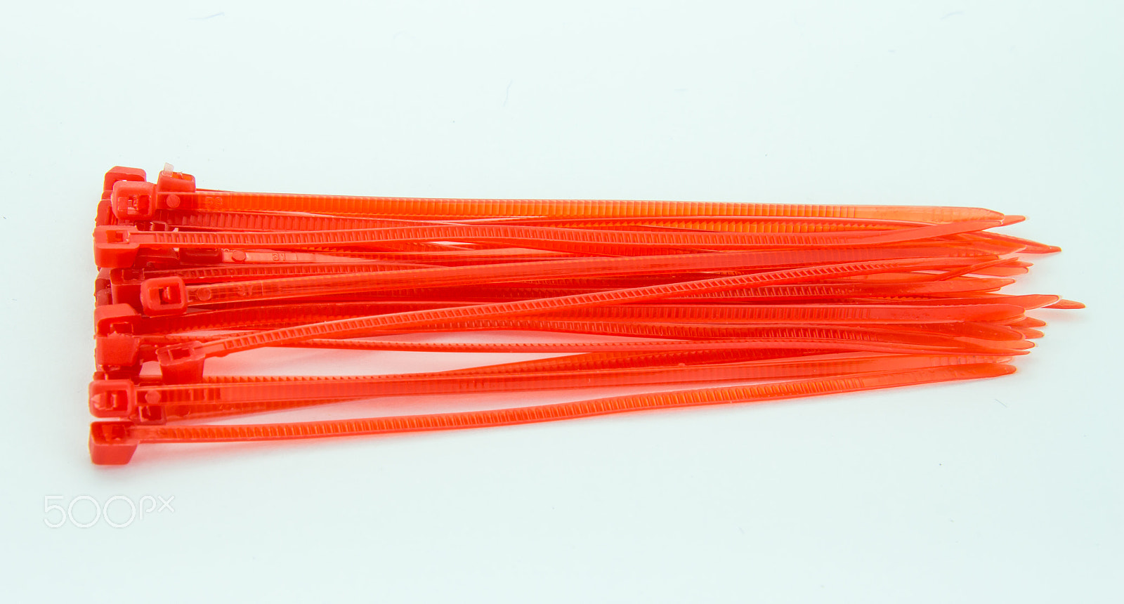 Canon EOS M sample photo. Red nylon cable ties on white background photography