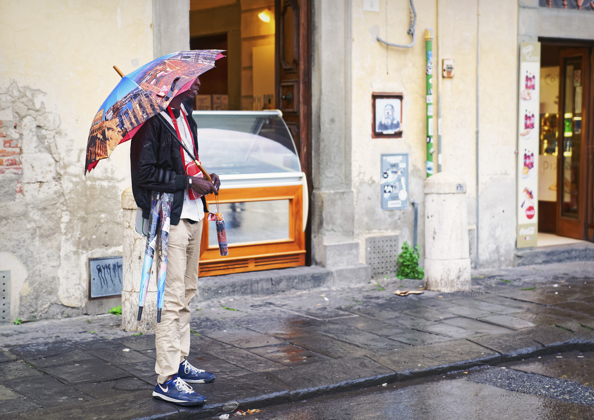 Sony a9 sample photo. Italy pisa black umbrella vendor in the rain in color photography