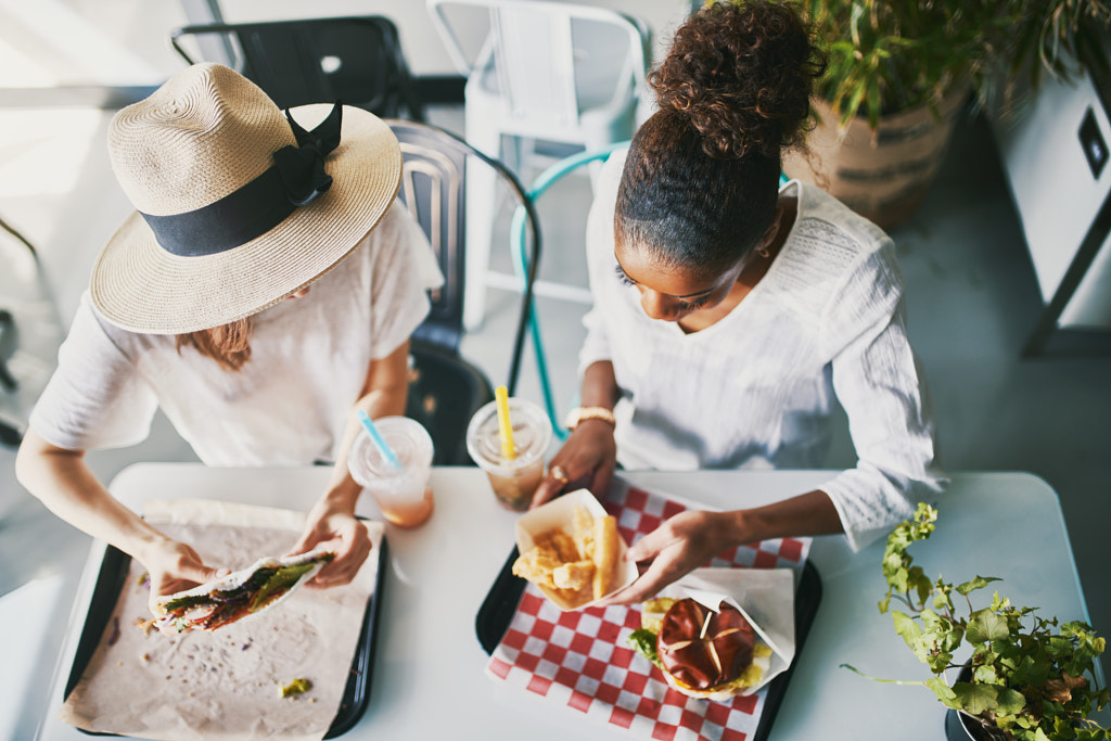 two friends eating healthy vegan food at restaurant together by Joshua Resnick on 500px.com