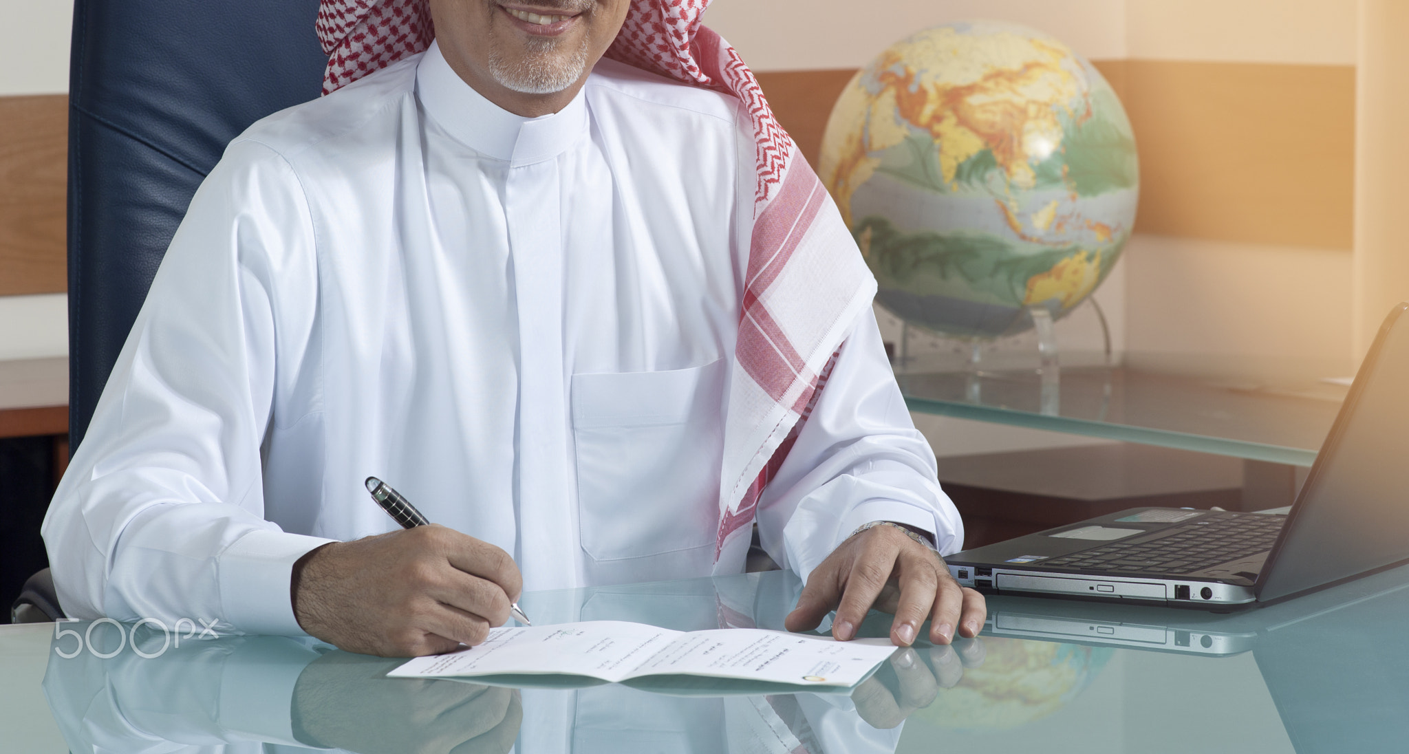 Senior Saudi Businessman Hand Writing At His Desk