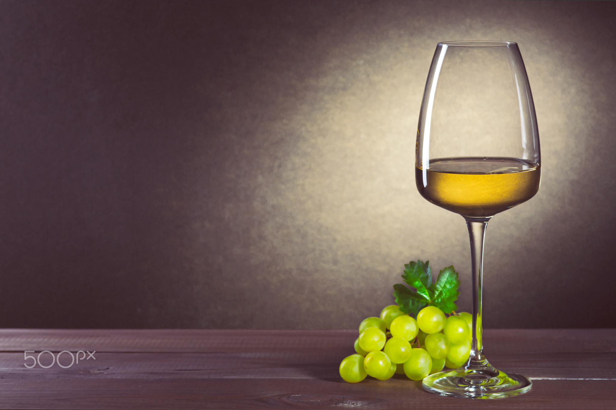 Glass of white wine on vintage wooden table