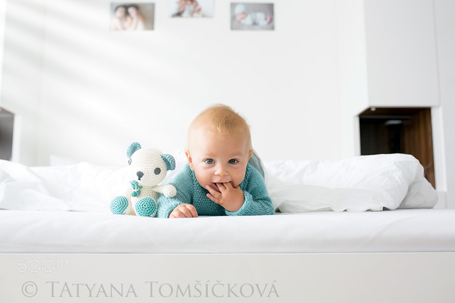 Little cute baby boy, child in knitted sweater, holding knitted