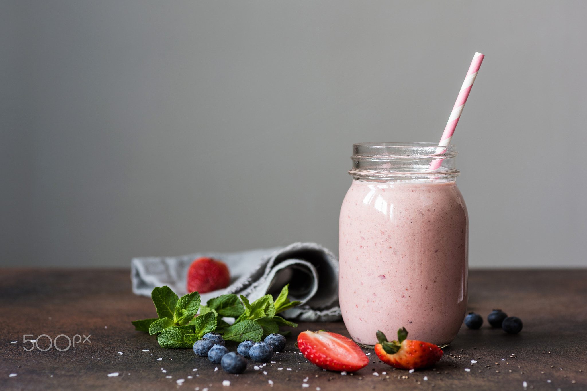 Strawberry smoothie in a jar on gray background