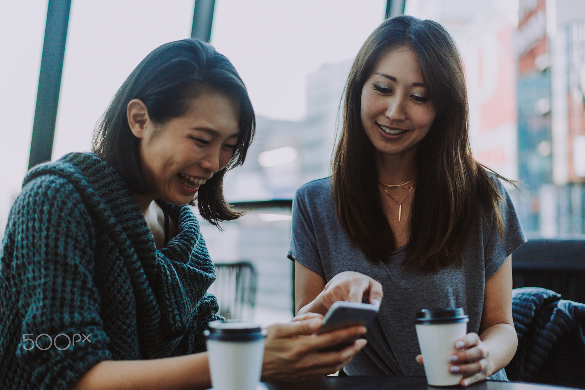 Two japanese women around in Tokyo during daytime. Making shoppi