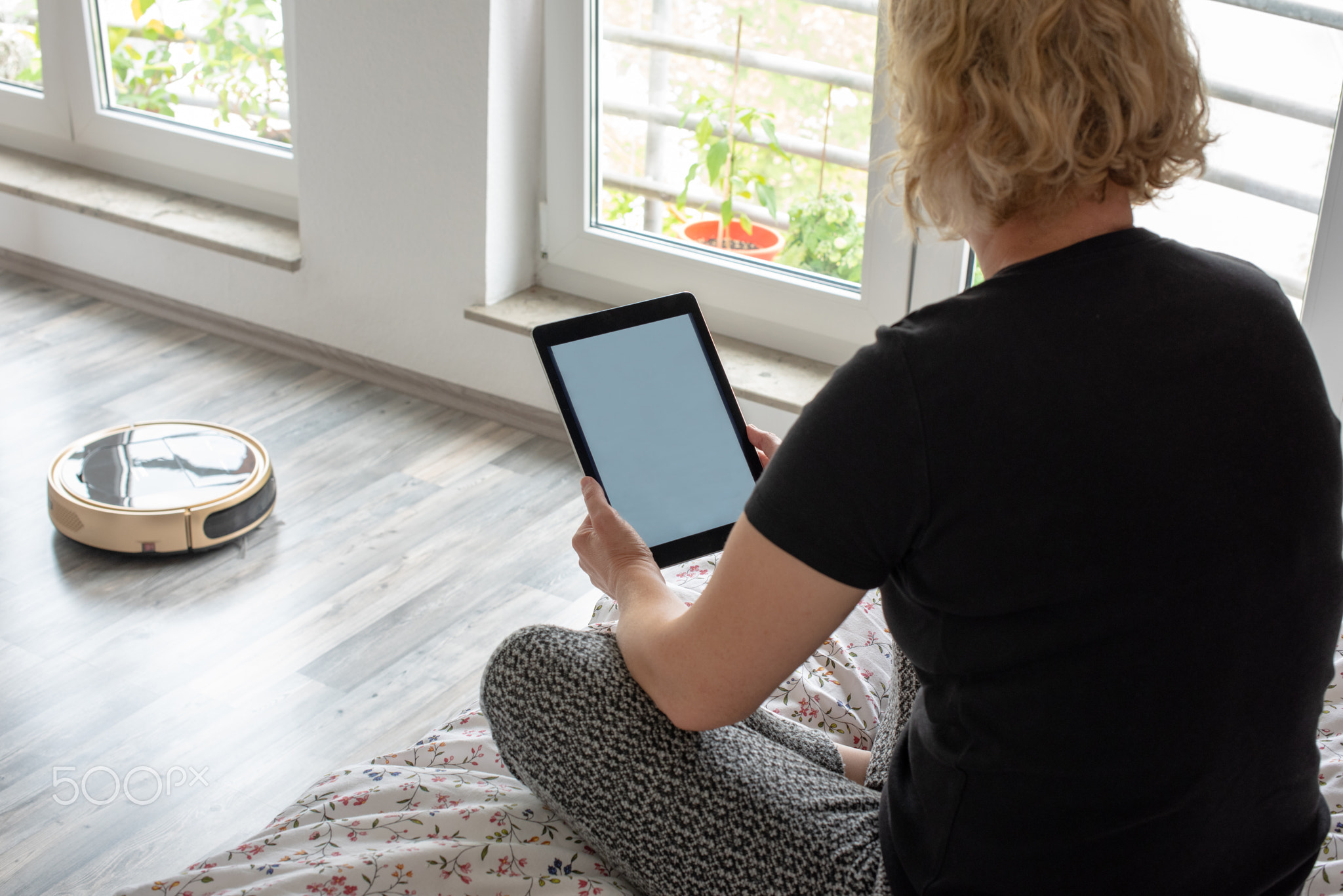 Vacuum cleaning robot with woman reading