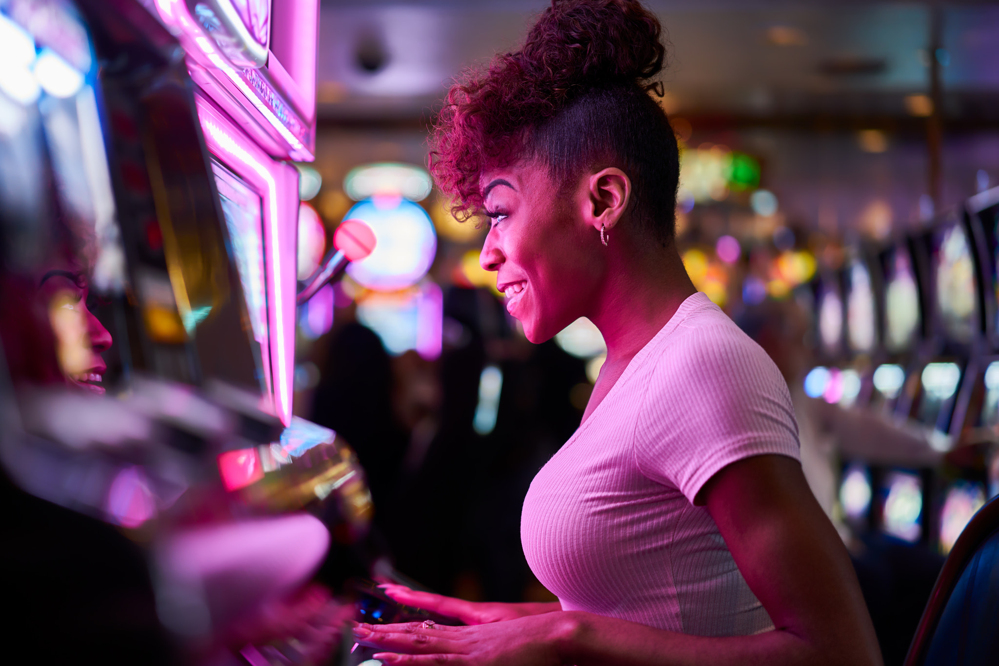 happy woman gambling at casino playing slot machine