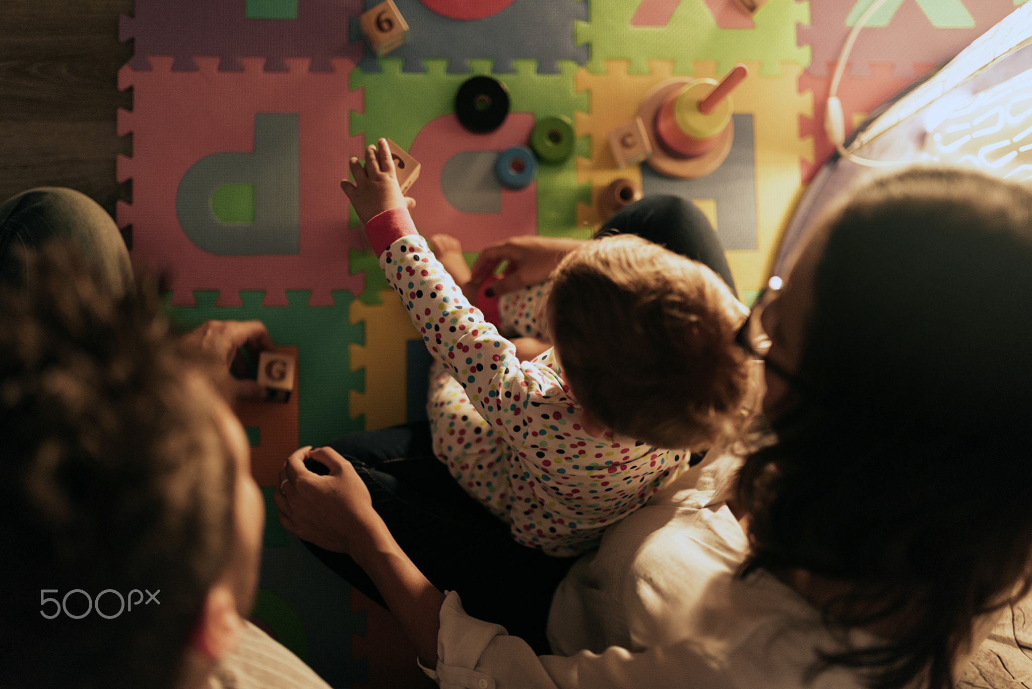 Parents enjoying playing with their son at home.