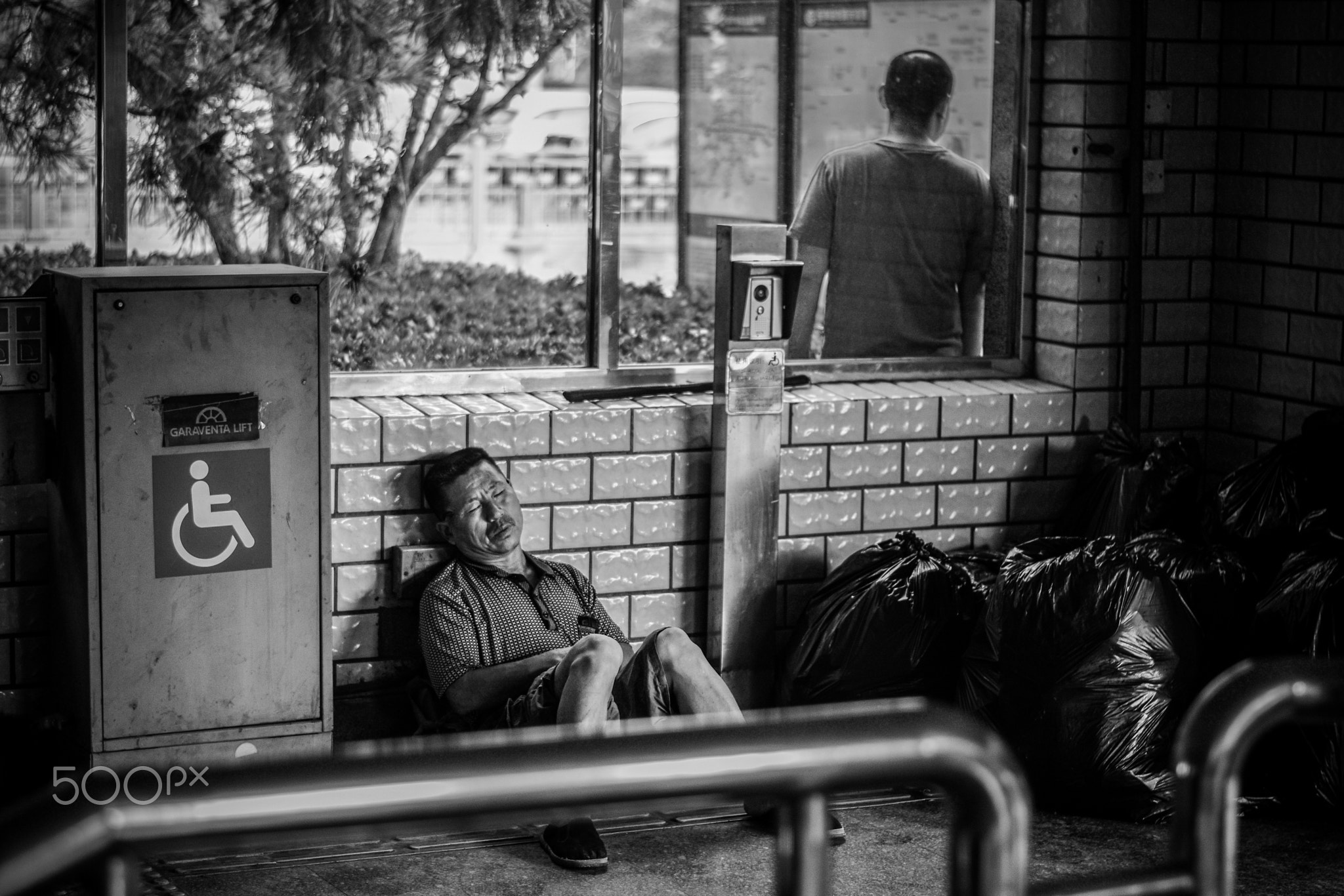 Sleeping next to garbage bags in metro