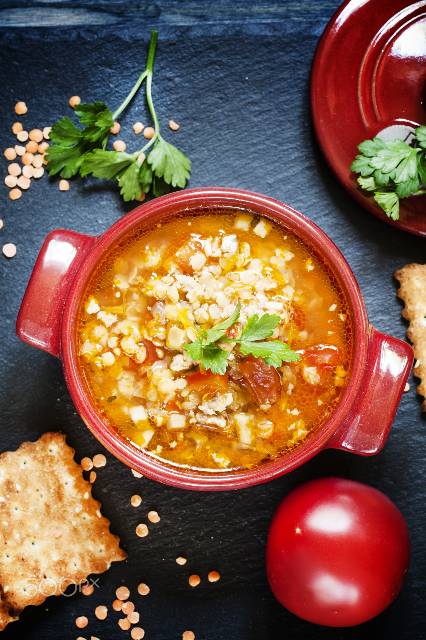 Tomato soup with red lentils and minced meat in a saucepan of se