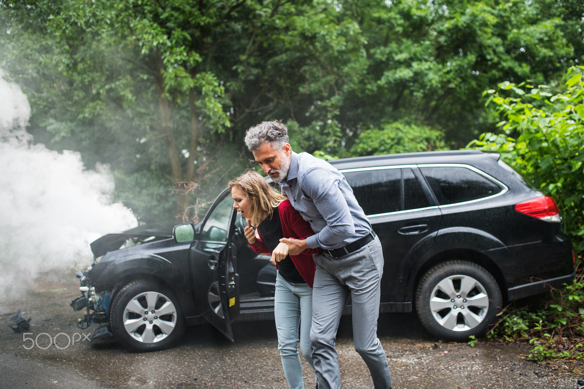 A mature man helping a young woman to walk after a car accident.