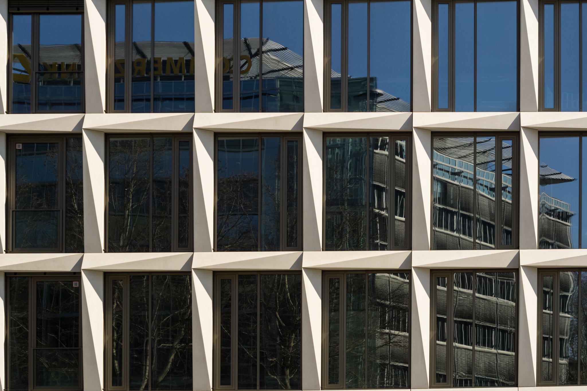 Reflections of a bank building on the windows of a business building