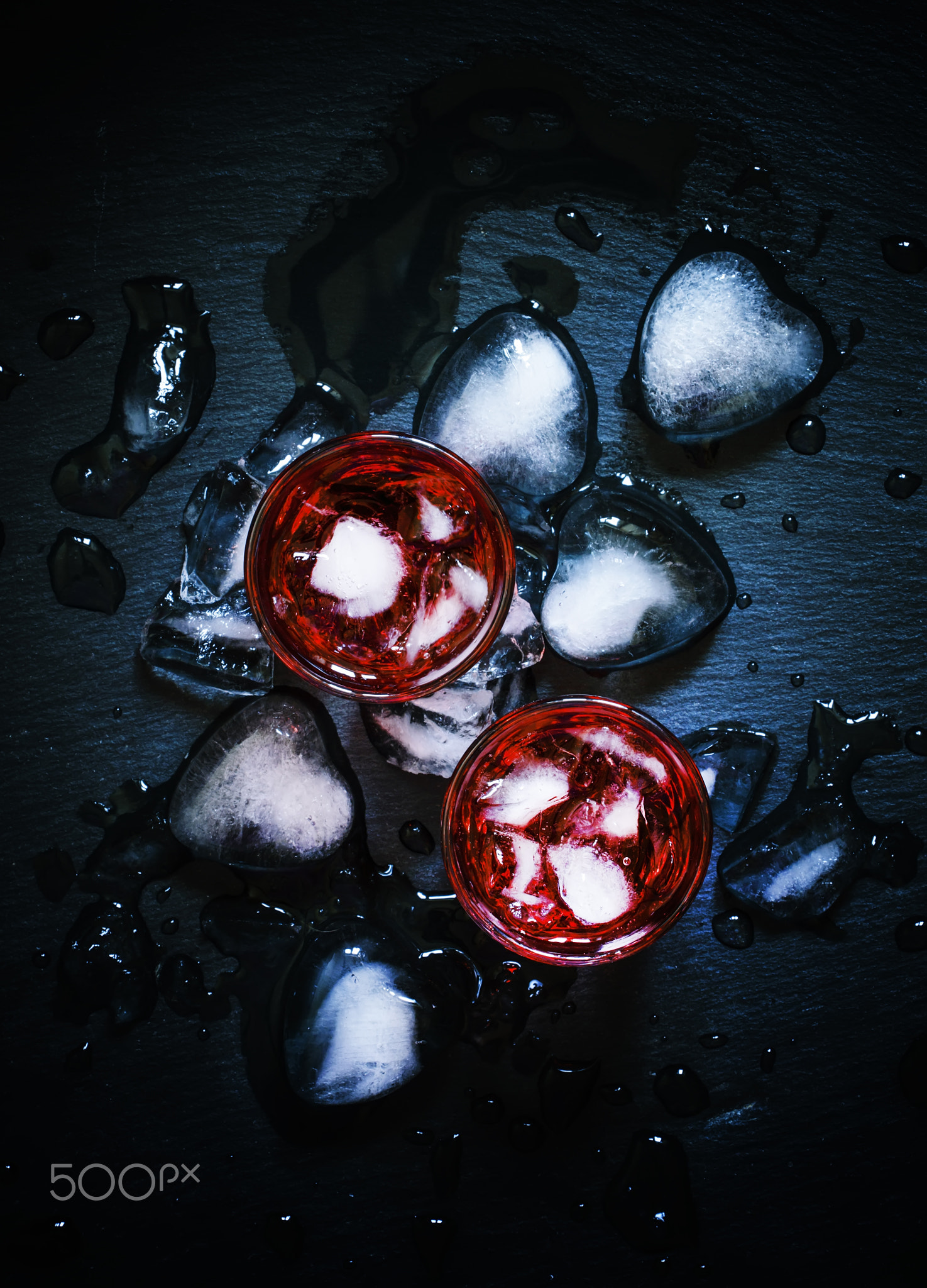 Red cocktail with crushed ice on a black background, top view