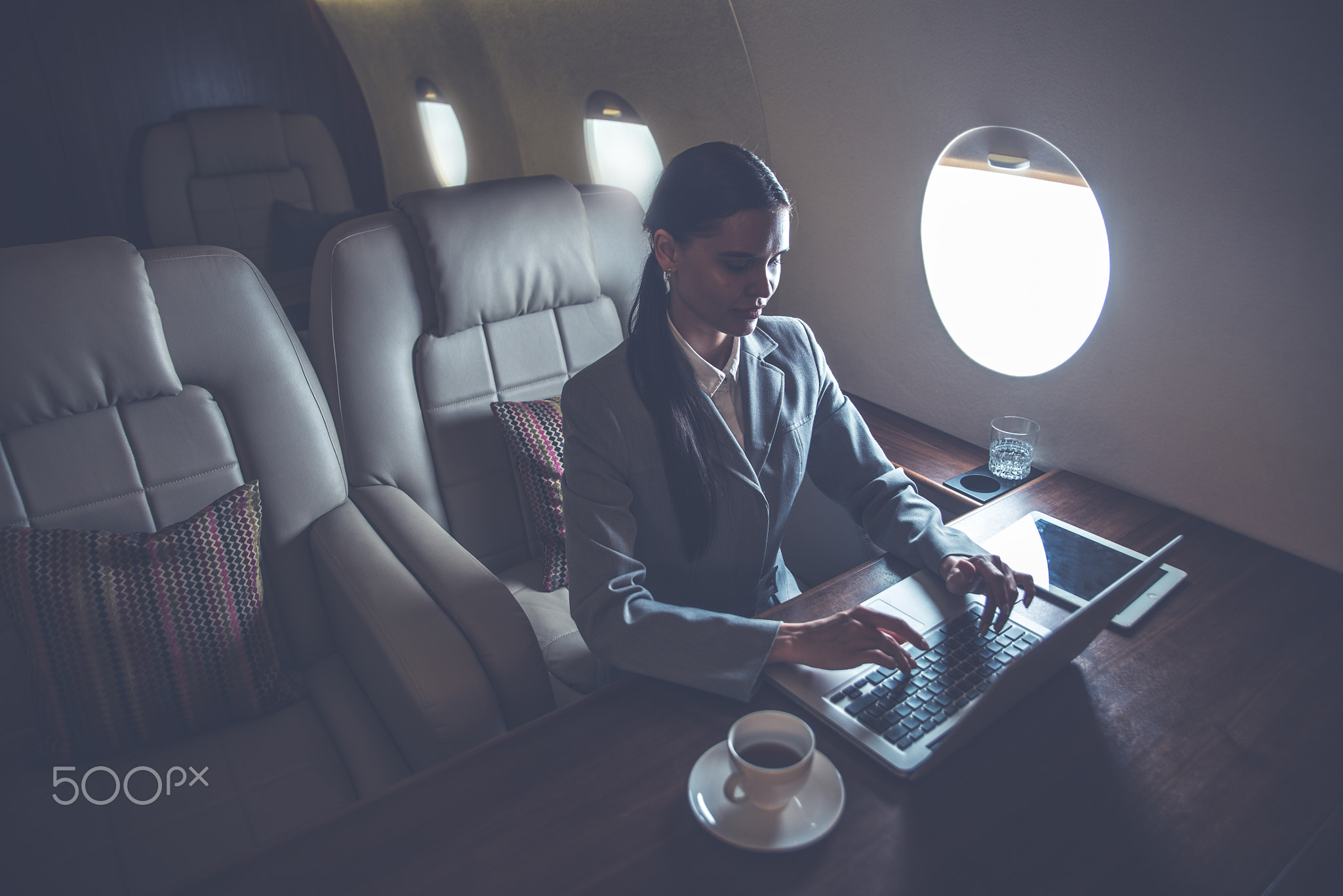 Business woman traveling and working on the private jet