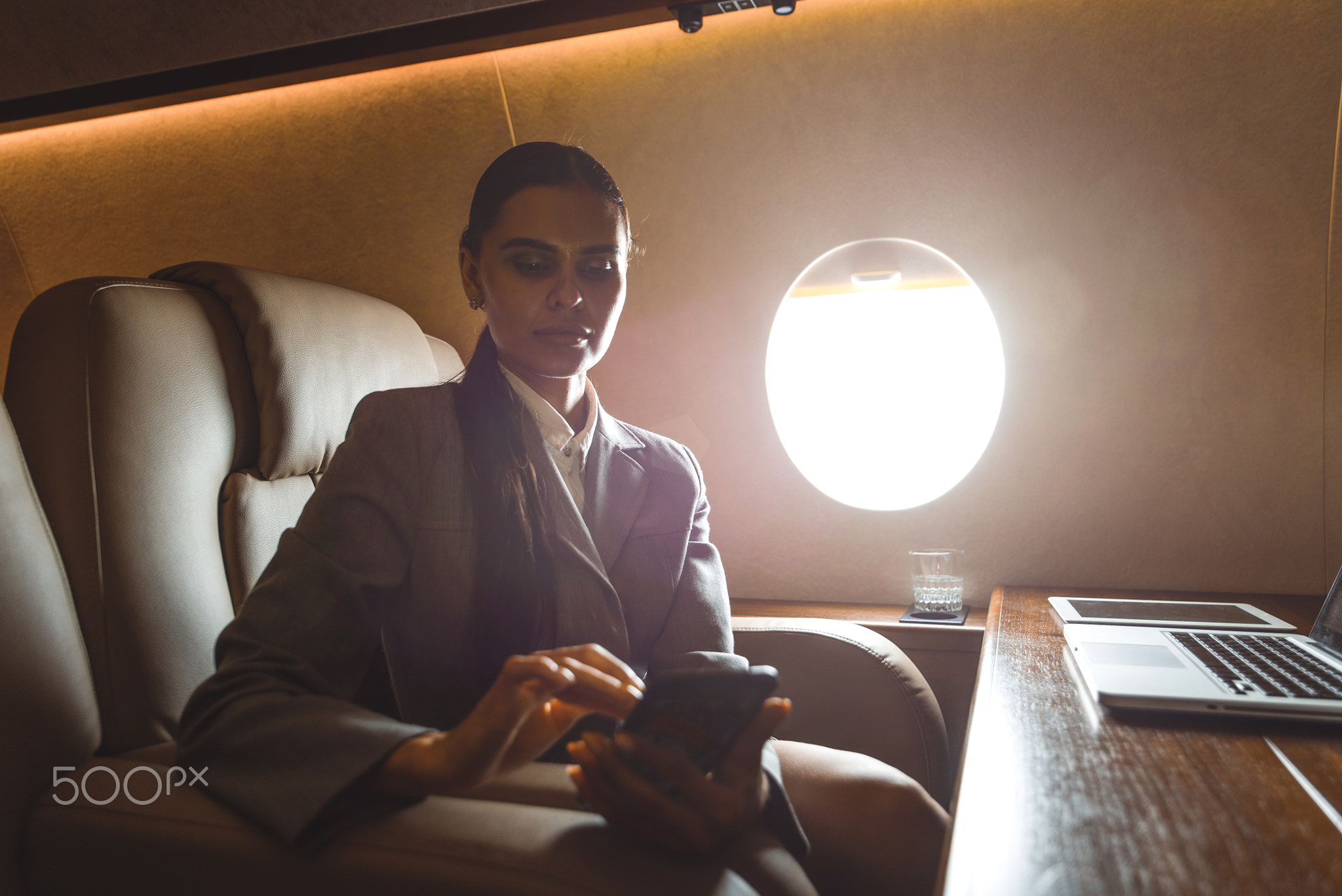Business woman traveling and working on the private jet