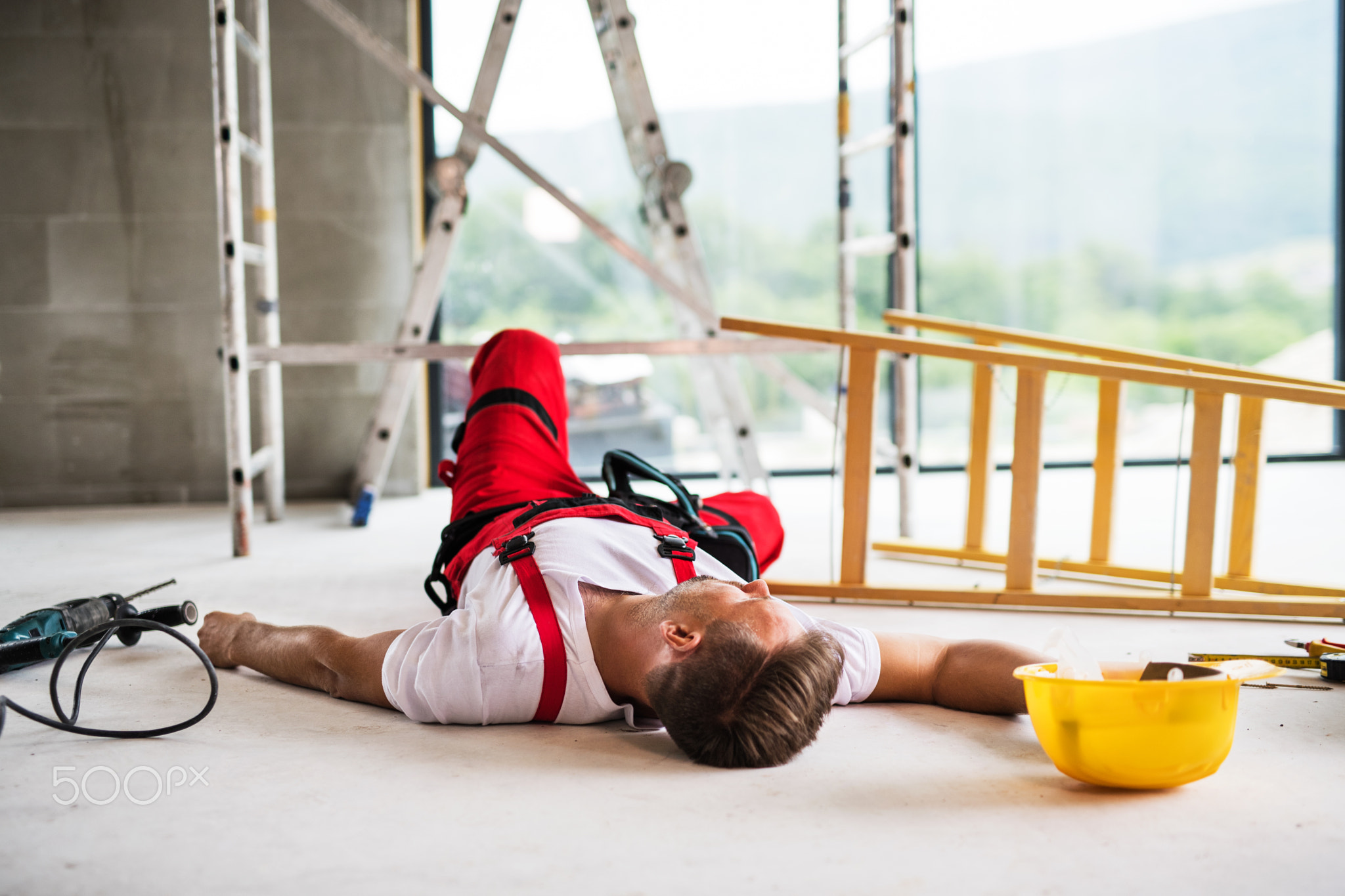 A man worker lying on the floor after an accident at the construction site.