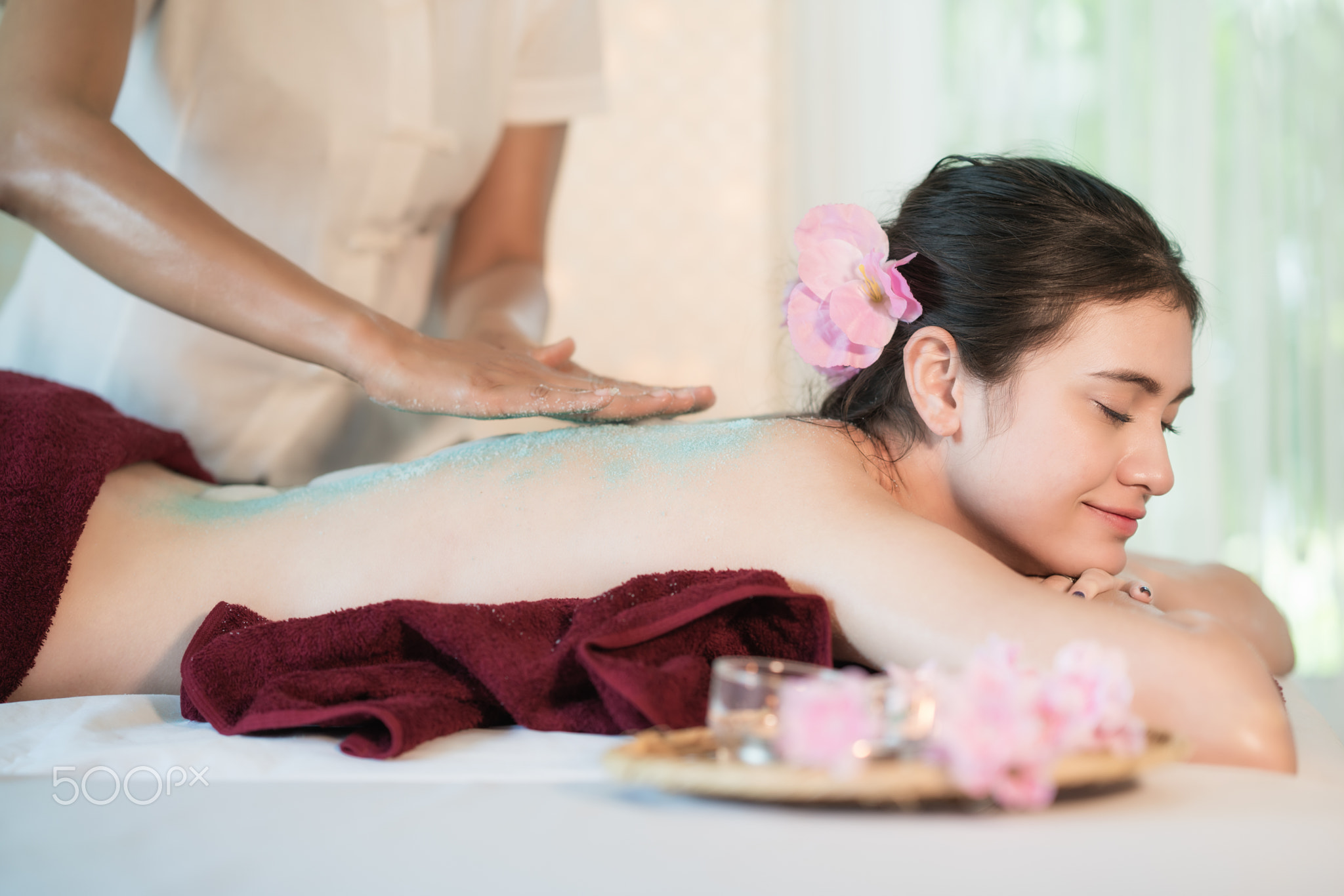 Young Asian woman receiving salt massage in spa salon, Hand putt