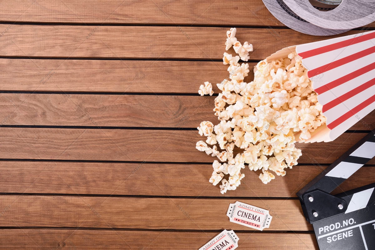 Popcorn tickets and cinema objects on wooden table