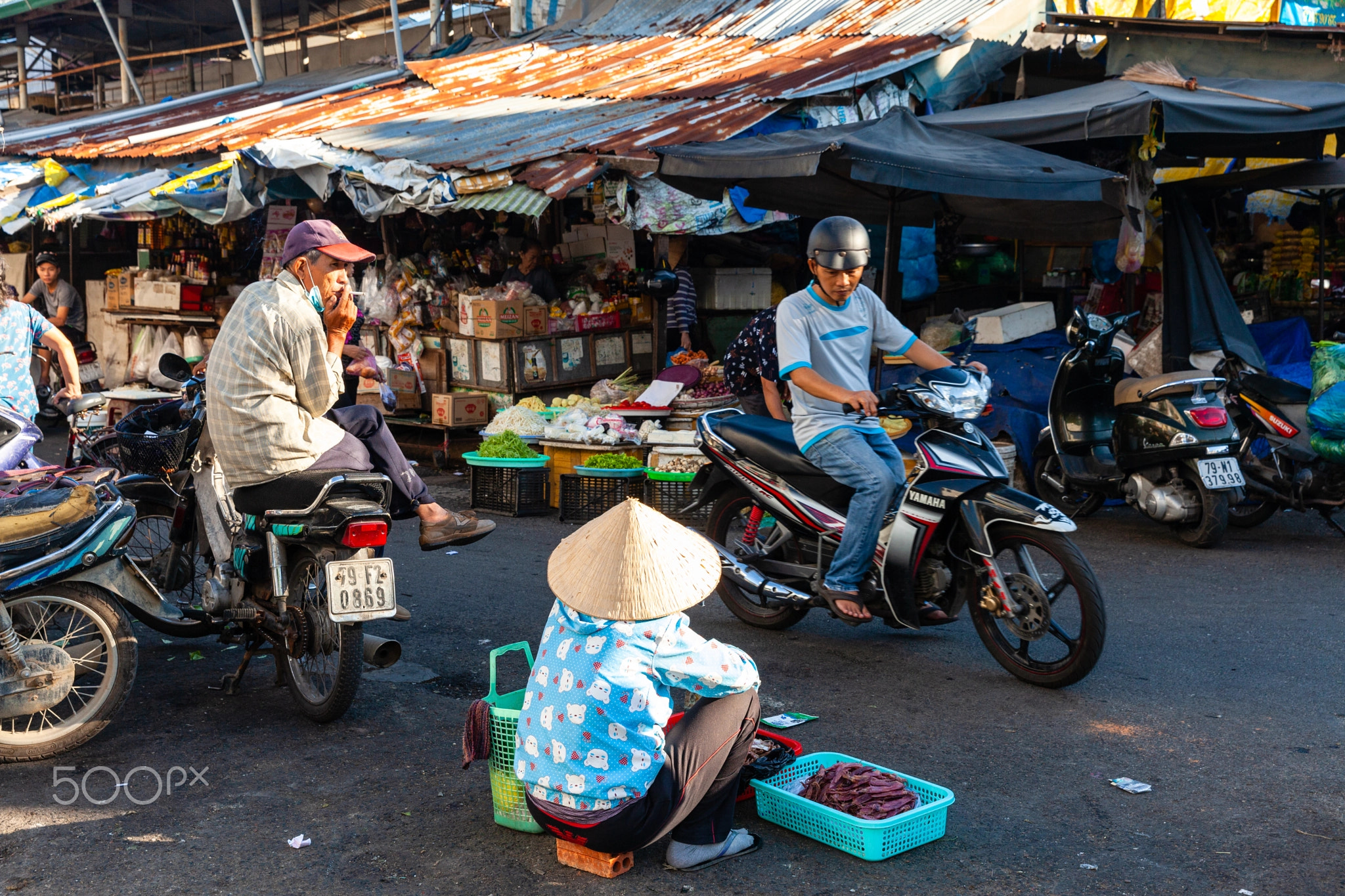 A woman sells dried fish at the street market