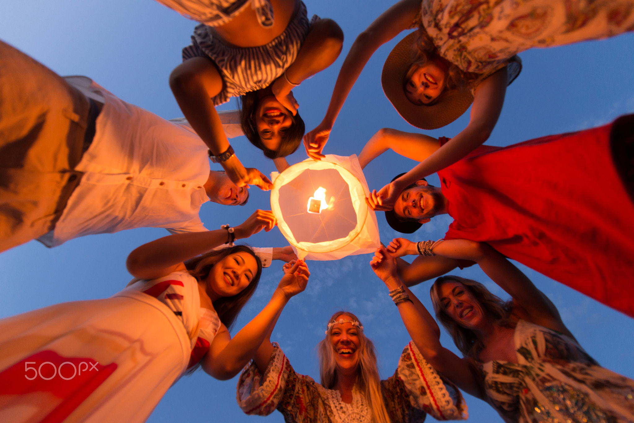 Group of friends lighting lanterns