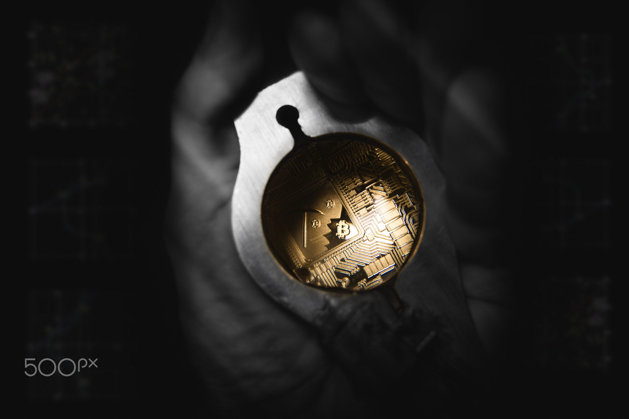 Golden Bitcoin under loupe