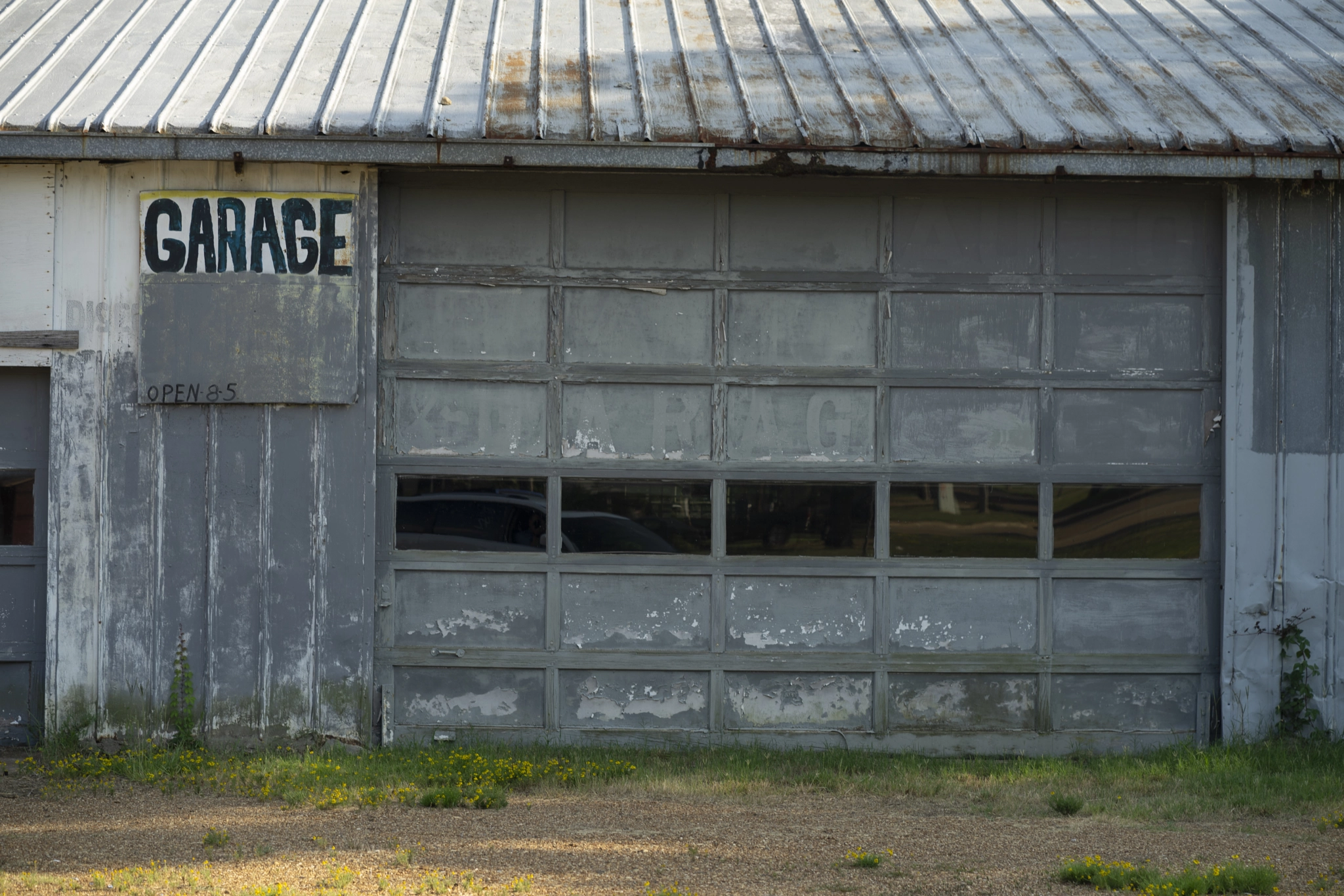 Abandoned Blue Garage Building Hand Written Sign