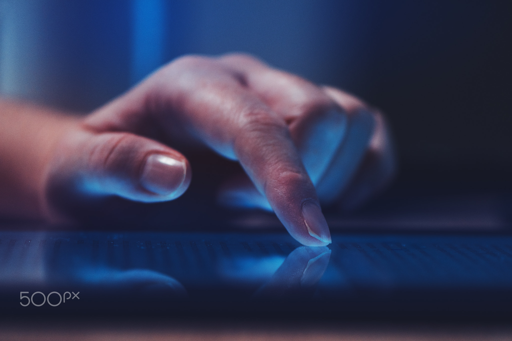 Extreme close up of female finger using digital tablet computer