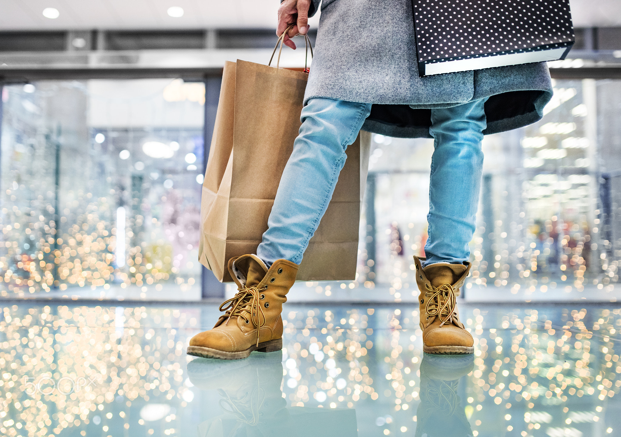 Legs of senior woman with bag doing Christmas shopping.