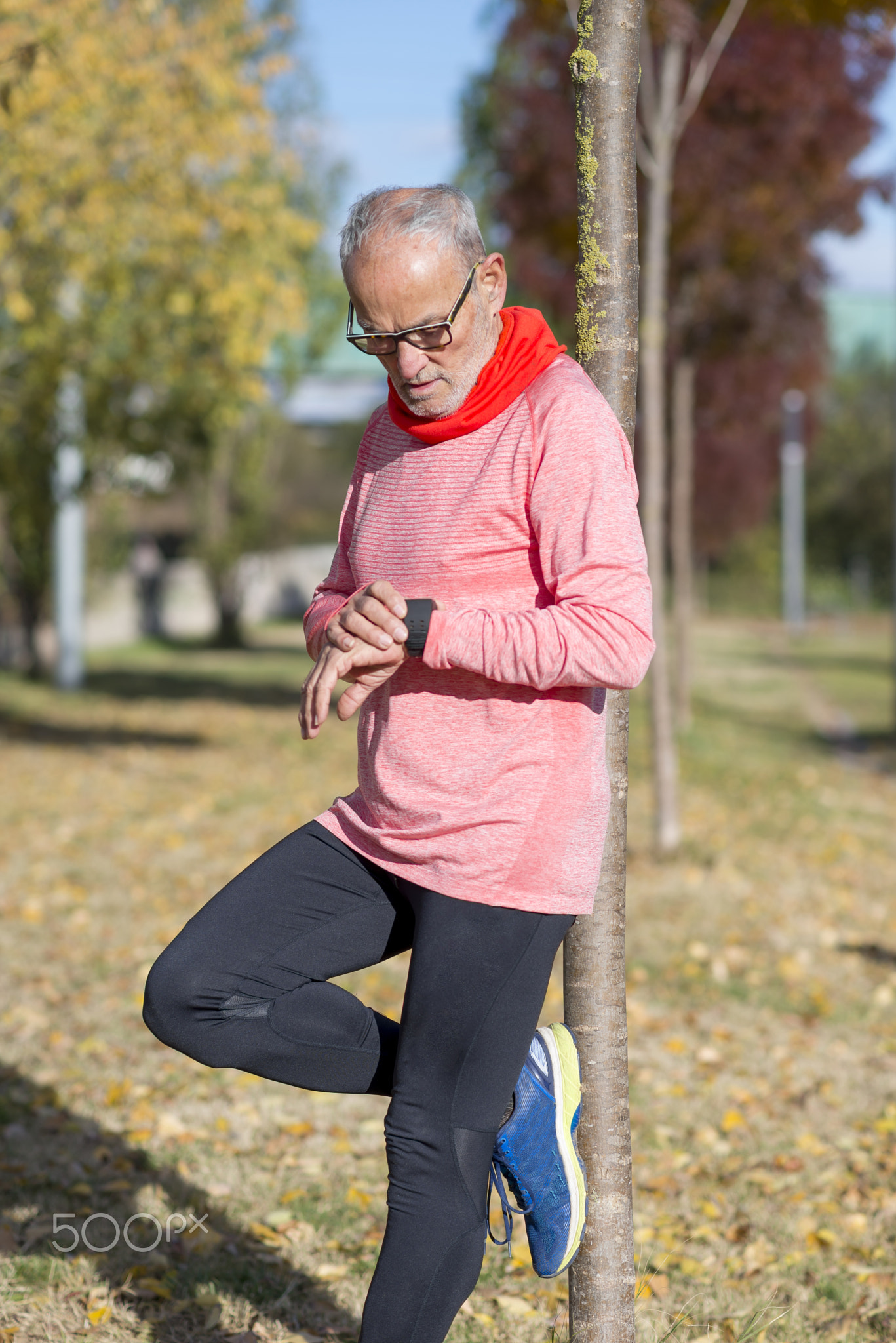 Senior runner man resting at the park while monitoring his exerc