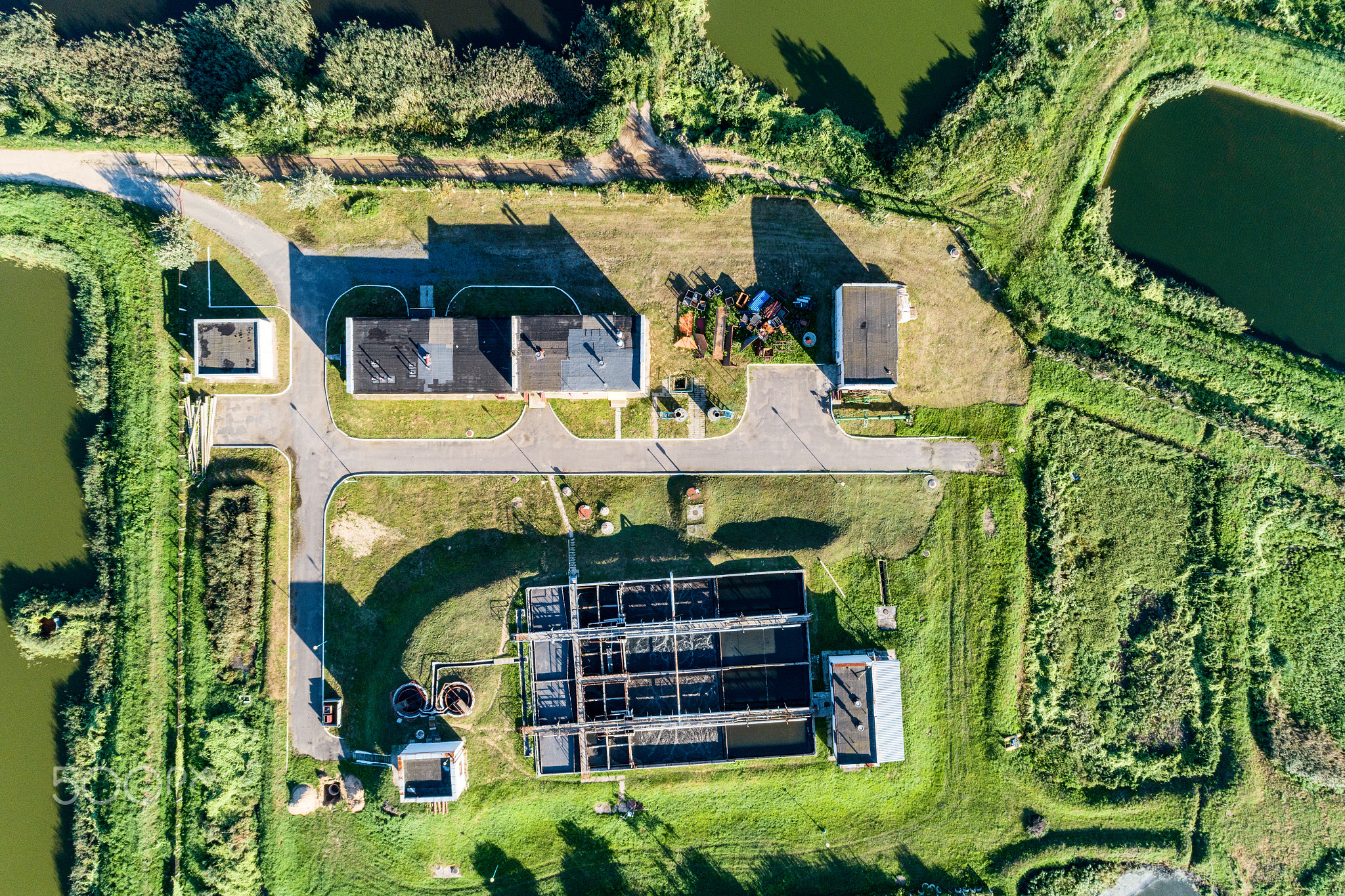 Aerial view of ity station for wastewater treatment. A lot of ponds with dirty and cleaned water.